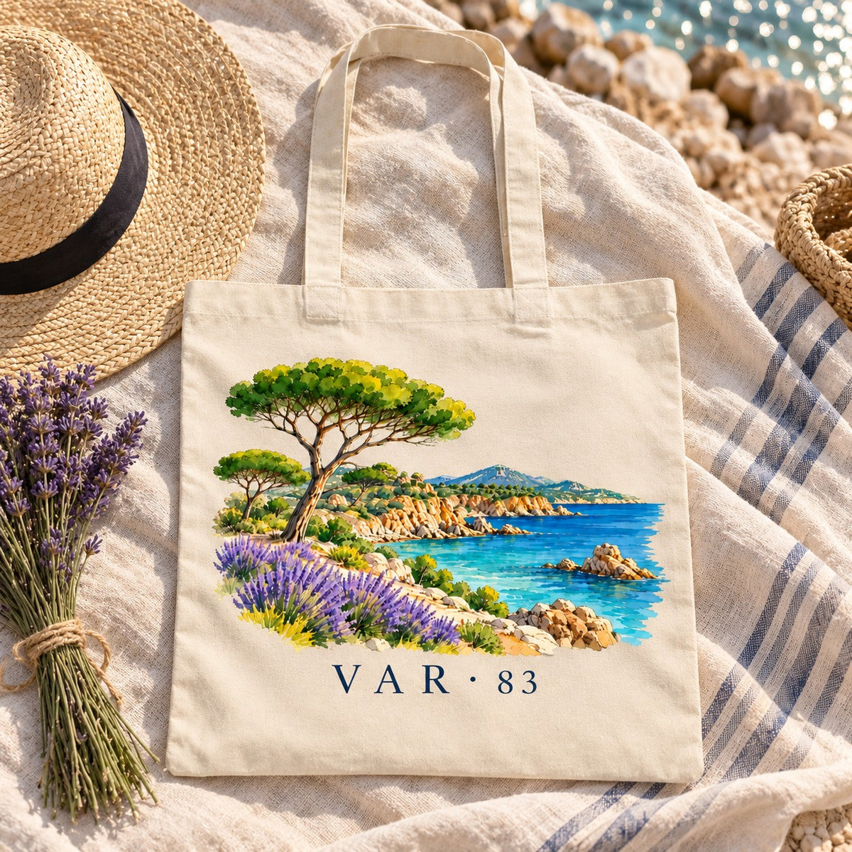 Tote bag Var (83) Essentiel posé sur une nappe avec un bouquet de lavande et un chapeau de paille