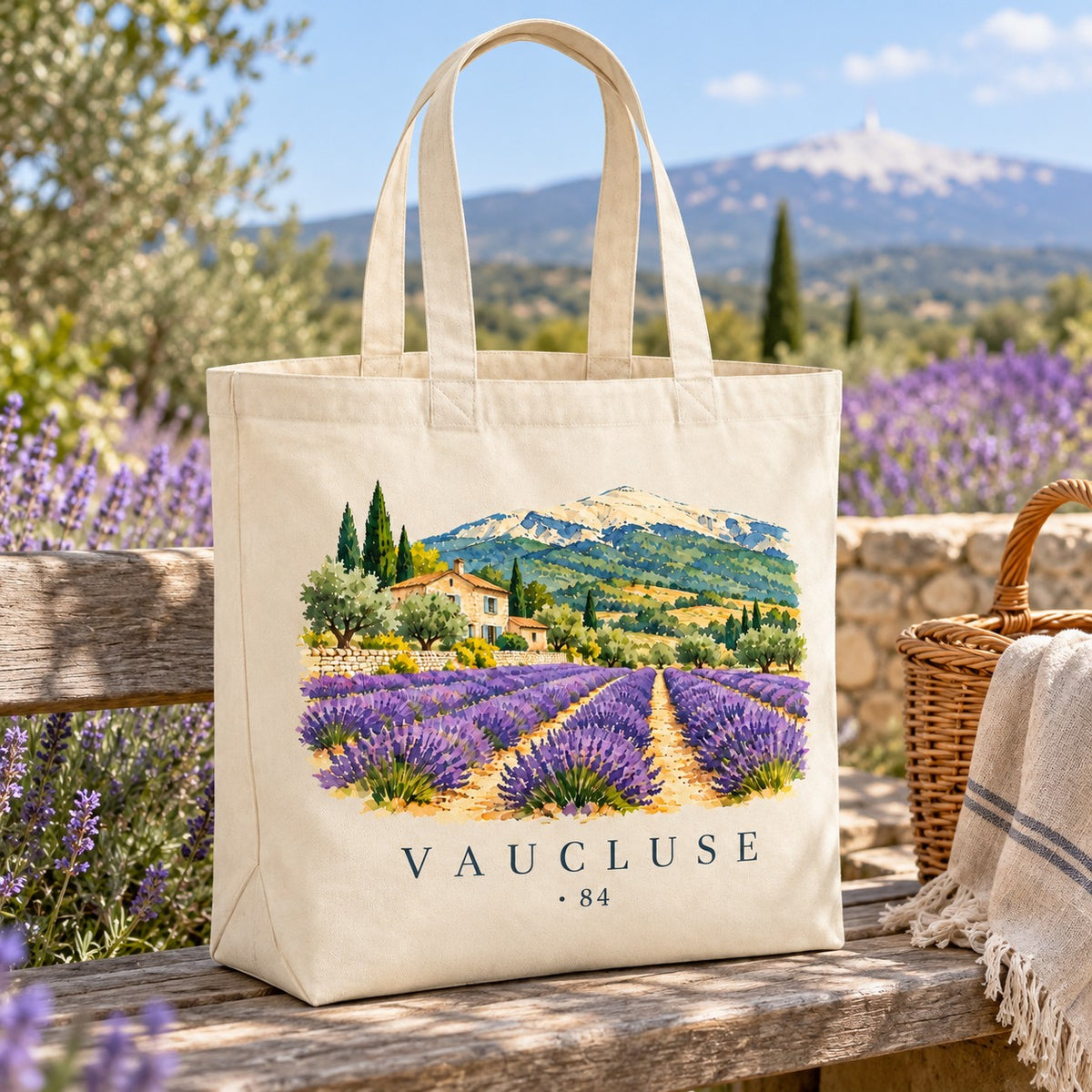 Tote bag Vaucluse (84) Premium posé sur un banc de bois au milieu des lavandes, avec un panier et un plaid