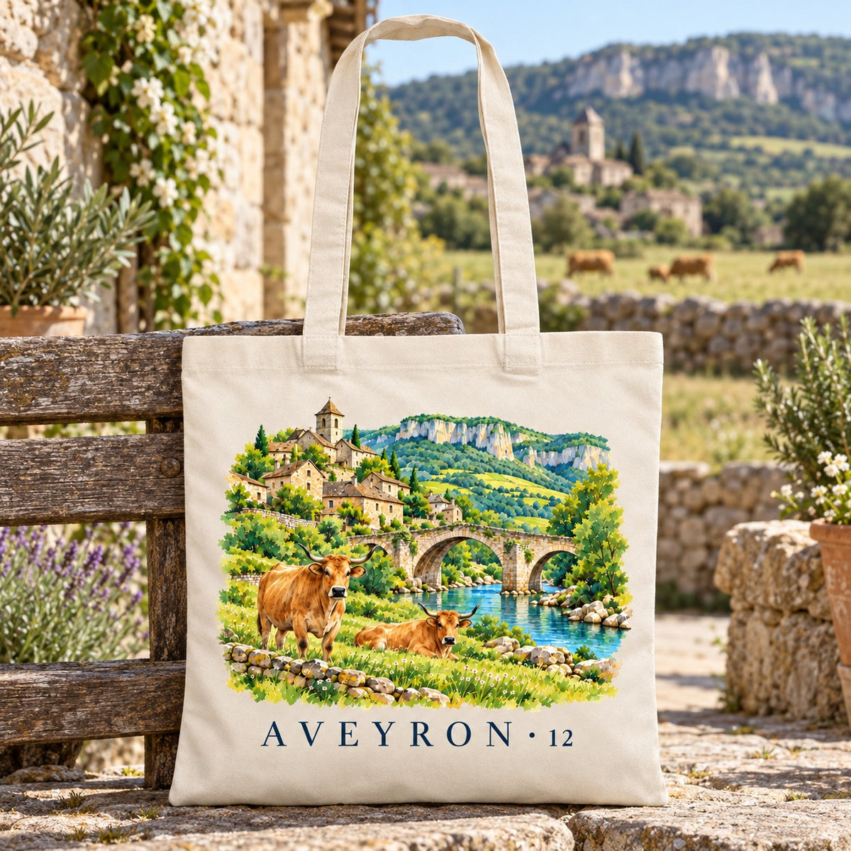 Tote bag Aveyron (12) Essentiel posé sur un banc de pierre, vaches au pré en arrière-plan