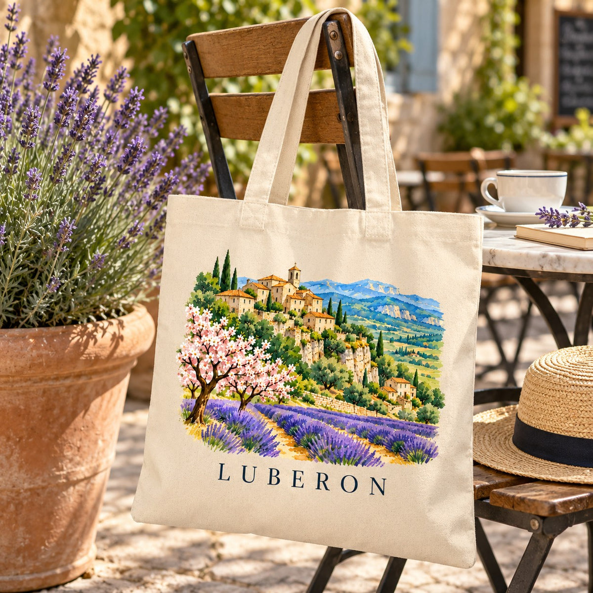 Tote bag Luberon Essentiel suspendu à une chaise en terrasse, près d'un pot de lavande