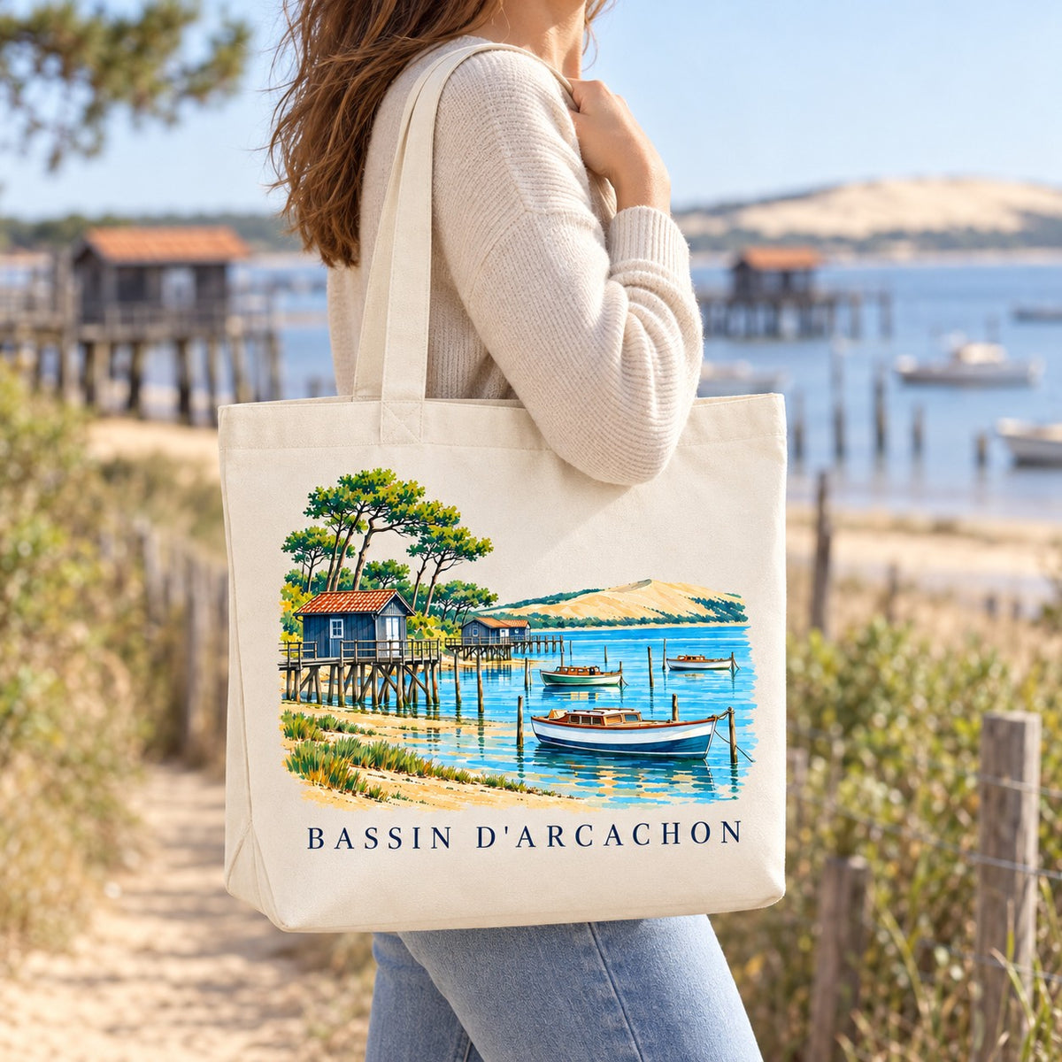 Tote bag Bassin d'Arcachon Premium porté à l'épaule sur un chemin de sable