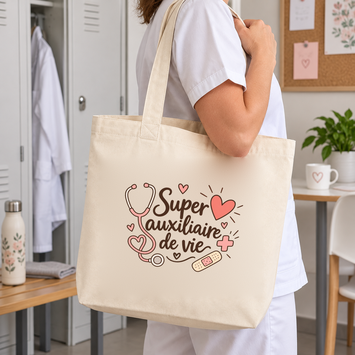 Tote bag auxiliaire de vie « Super auxiliaire de vie » Premium porté à l'épaule dans un vestiaire, en tenue de travail