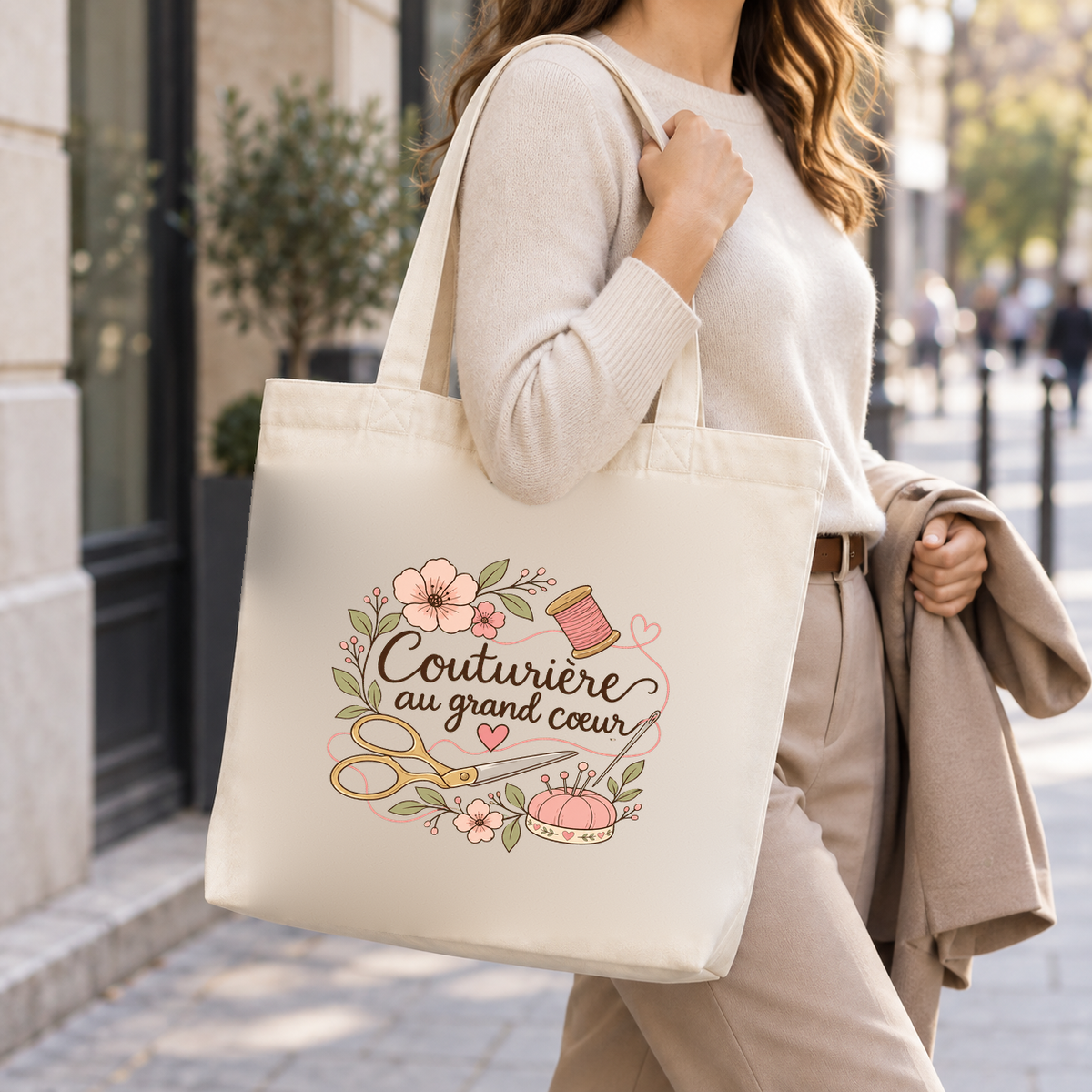 Tote bag couturière « Couturière au grand cœur » Premium porté à l'épaule dans la rue, une veste sur le bras