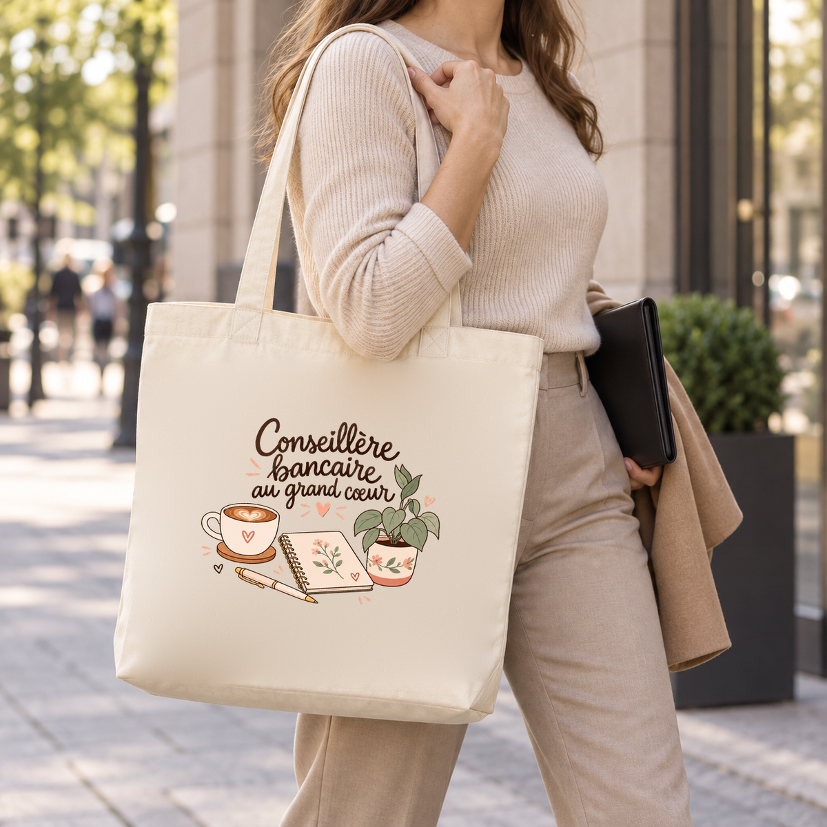 Tote bag conseillère bancaire « Conseillère bancaire au grand cœur » Premium porté à l'épaule dans la rue, un dossier sous le bras