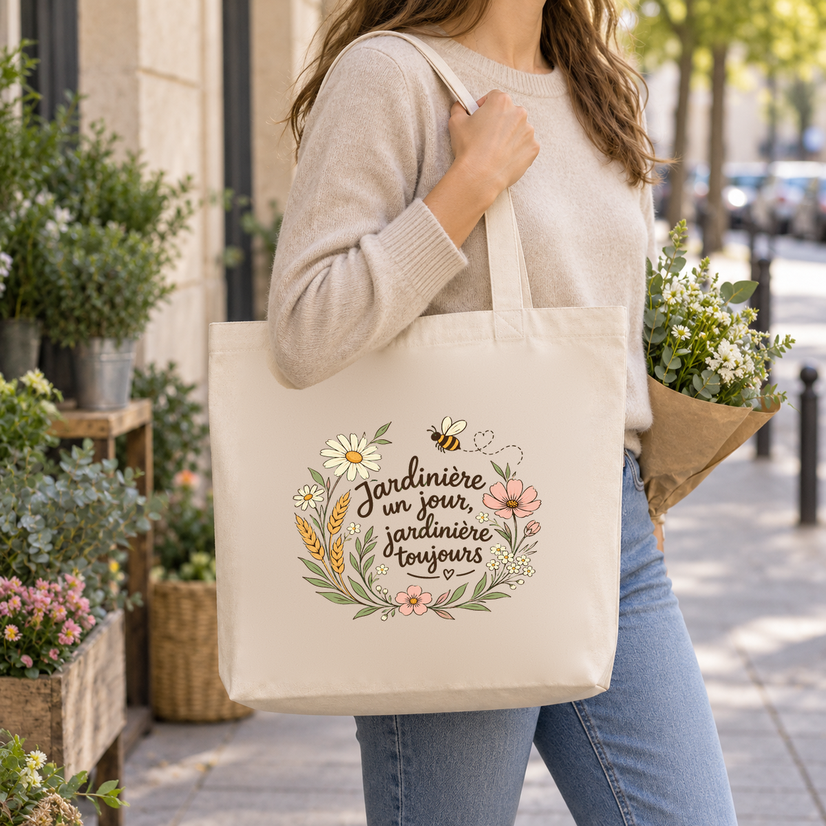 Tote bag jardinière « Jardinière un jour, jardinière toujours » Premium porté à l'épaule dans la rue, un bouquet de fleurs à la main