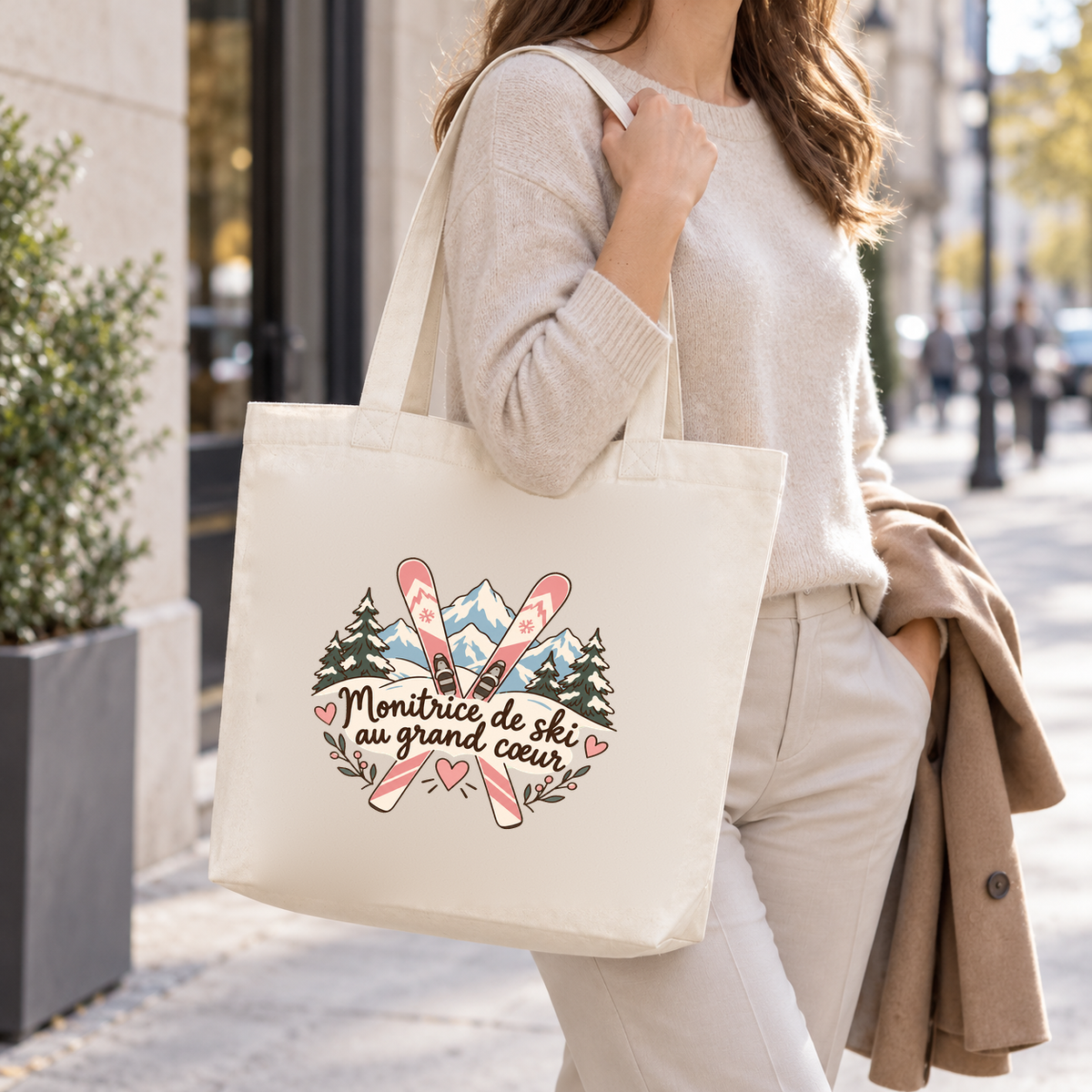 Tote bag monitrice de ski « Monitrice de ski au grand cœur » Premium porté à l'épaule dans la rue d'une station de ski