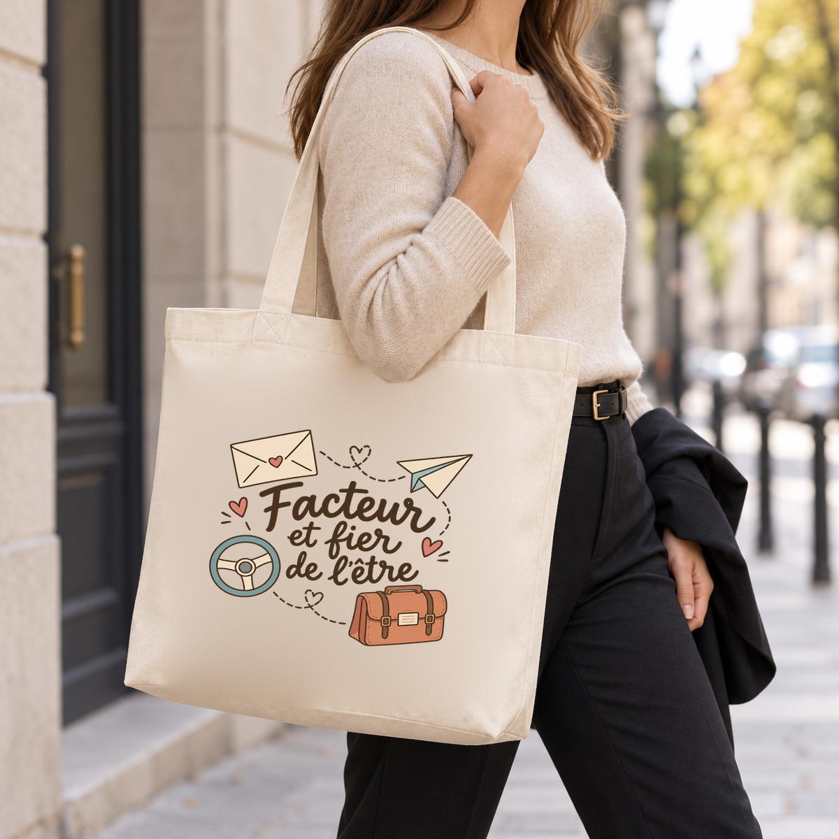 Tote bag facteur « Facteur et fier de l'être » Premium porté à l'épaule dans la rue, une veste sur le bras