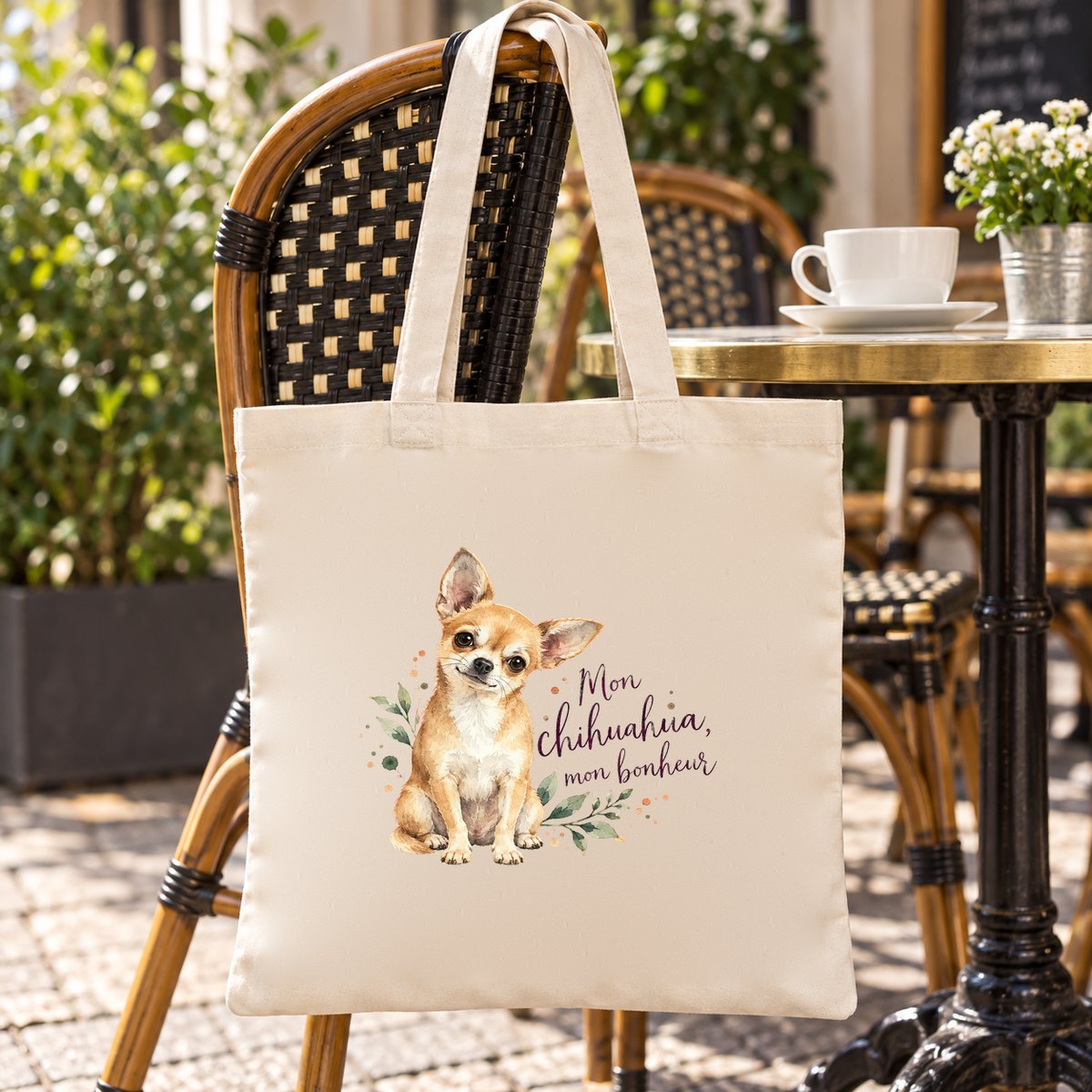 Tote bag chihuahua « Mon chihuahua, mon bonheur » Essentiel suspendu à une chaise de terrasse de café