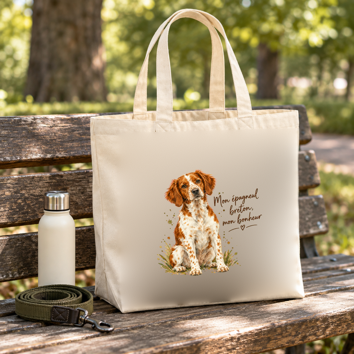 Tote bag épagneul breton « Mon épagneul breton, mon bonheur » Premium posé sur un banc de parc, à côté d'une gourde et d'une laisse