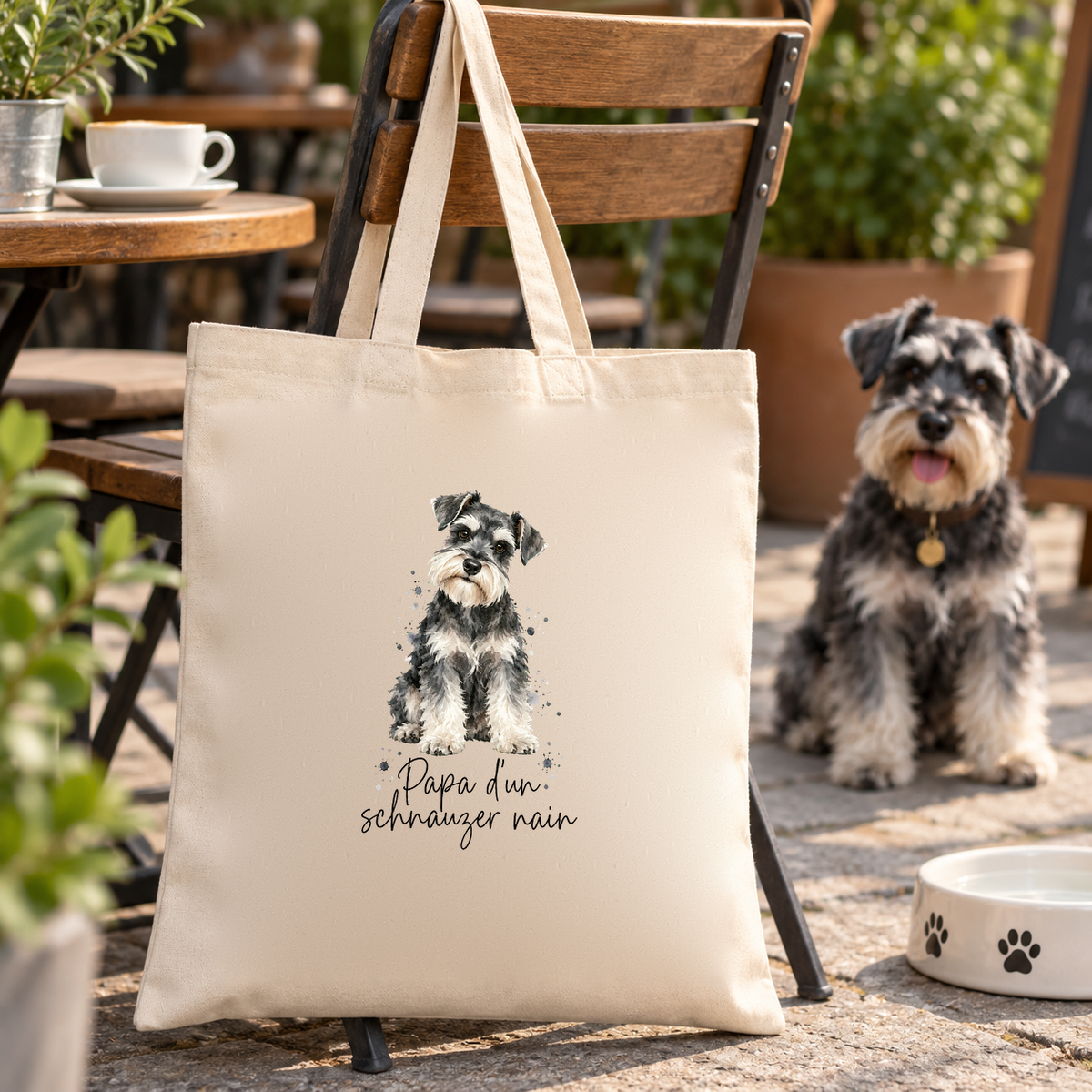 Tote bag schnauzer nain « Papa d'un schnauzer nain » Essentiel suspendu à une chaise de terrasse, un schnauzer nain juste à côté