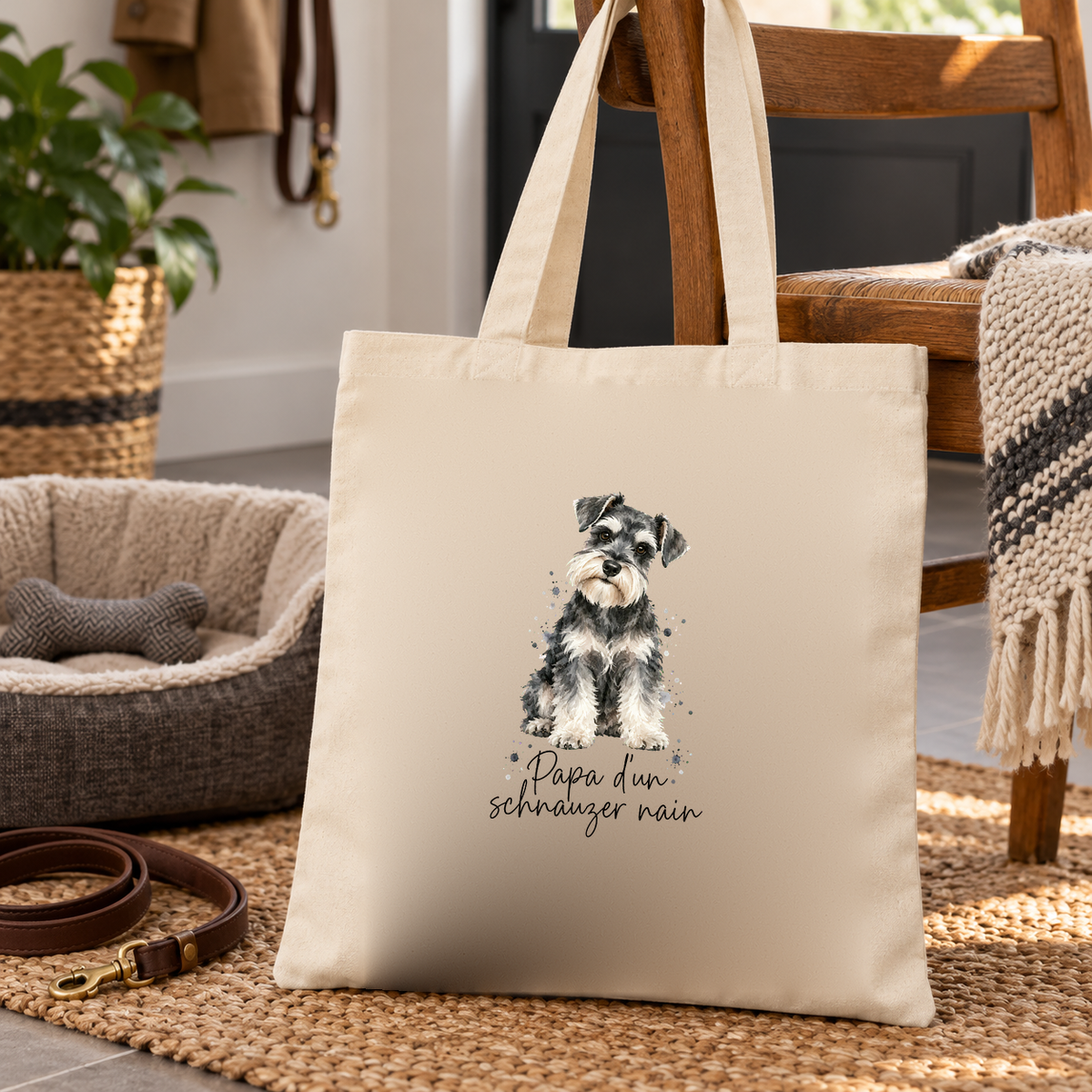 Tote bag schnauzer nain « Papa d'un schnauzer nain » Essentiel posé sur un tapis d'entrée, à côté d'un panier pour chien et d'une laisse