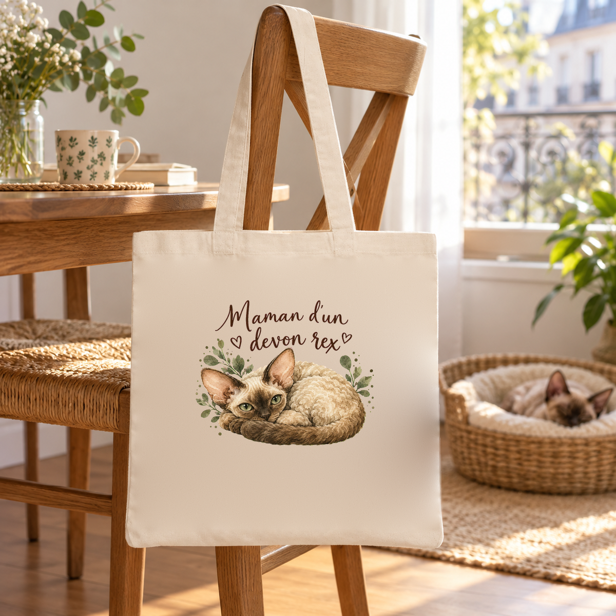 Tote bag devon rex « Maman d'un devon rex » Essentiel suspendu à une chaise de salle à manger, un chat endormi dans son panier