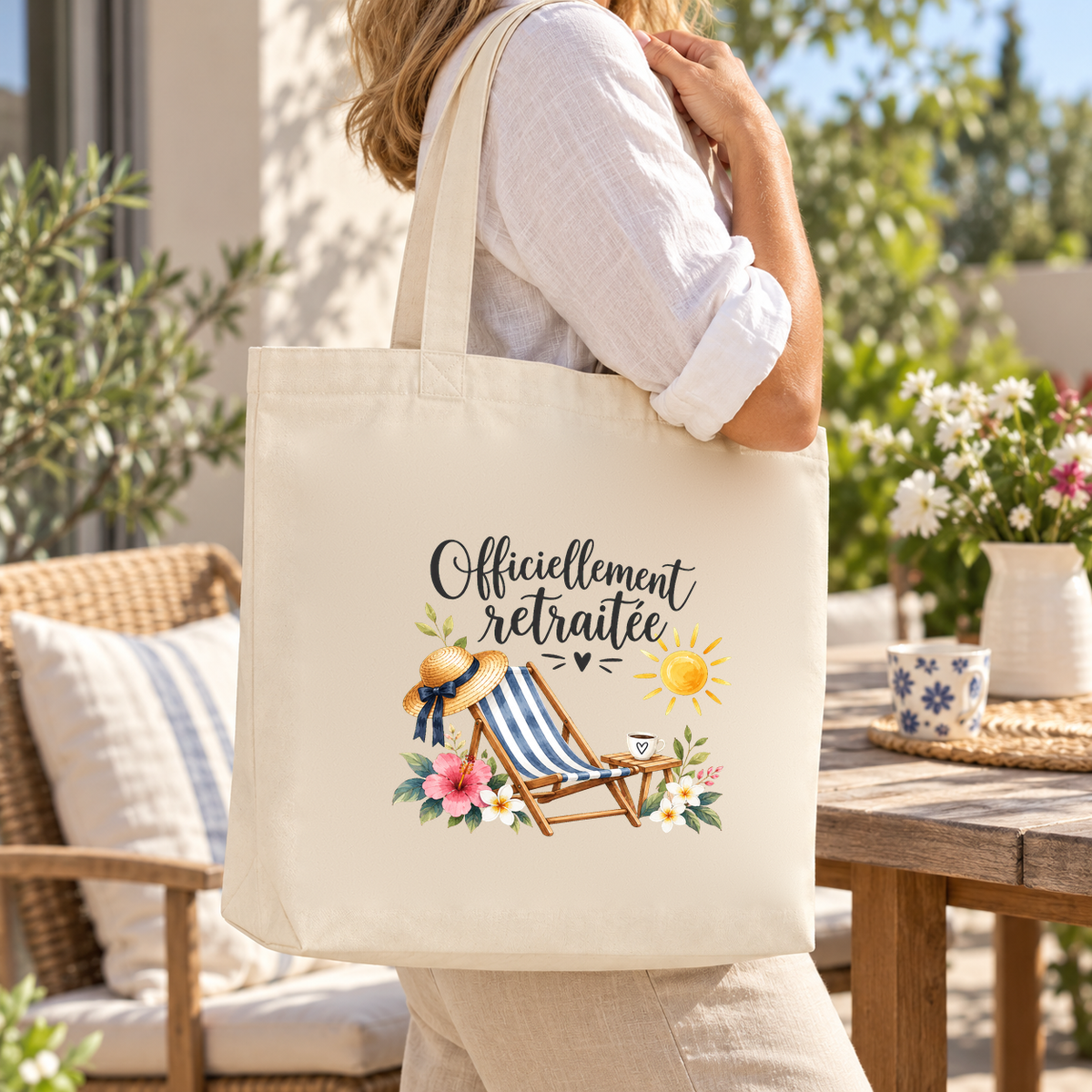 Tote bag retraite « Officiellement retraitée » Premium porté à l'épaule sur une terrasse ensoleillée au bord de la mer