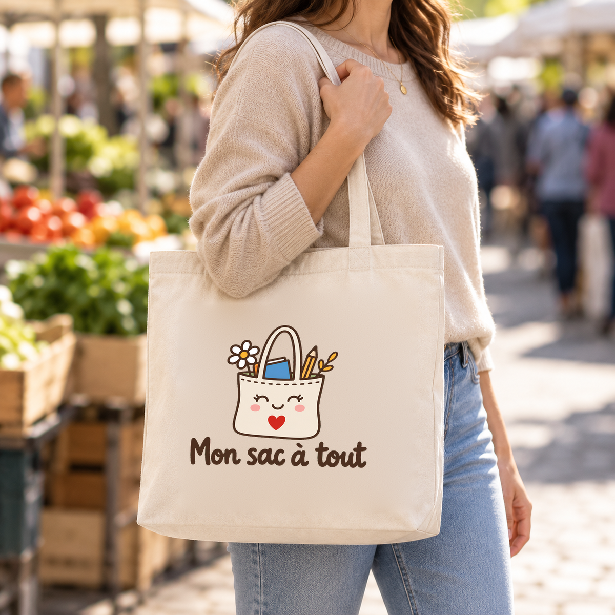Tote bag « Mon sac à tout » Premium porté à l'épaule dans un marché en plein air