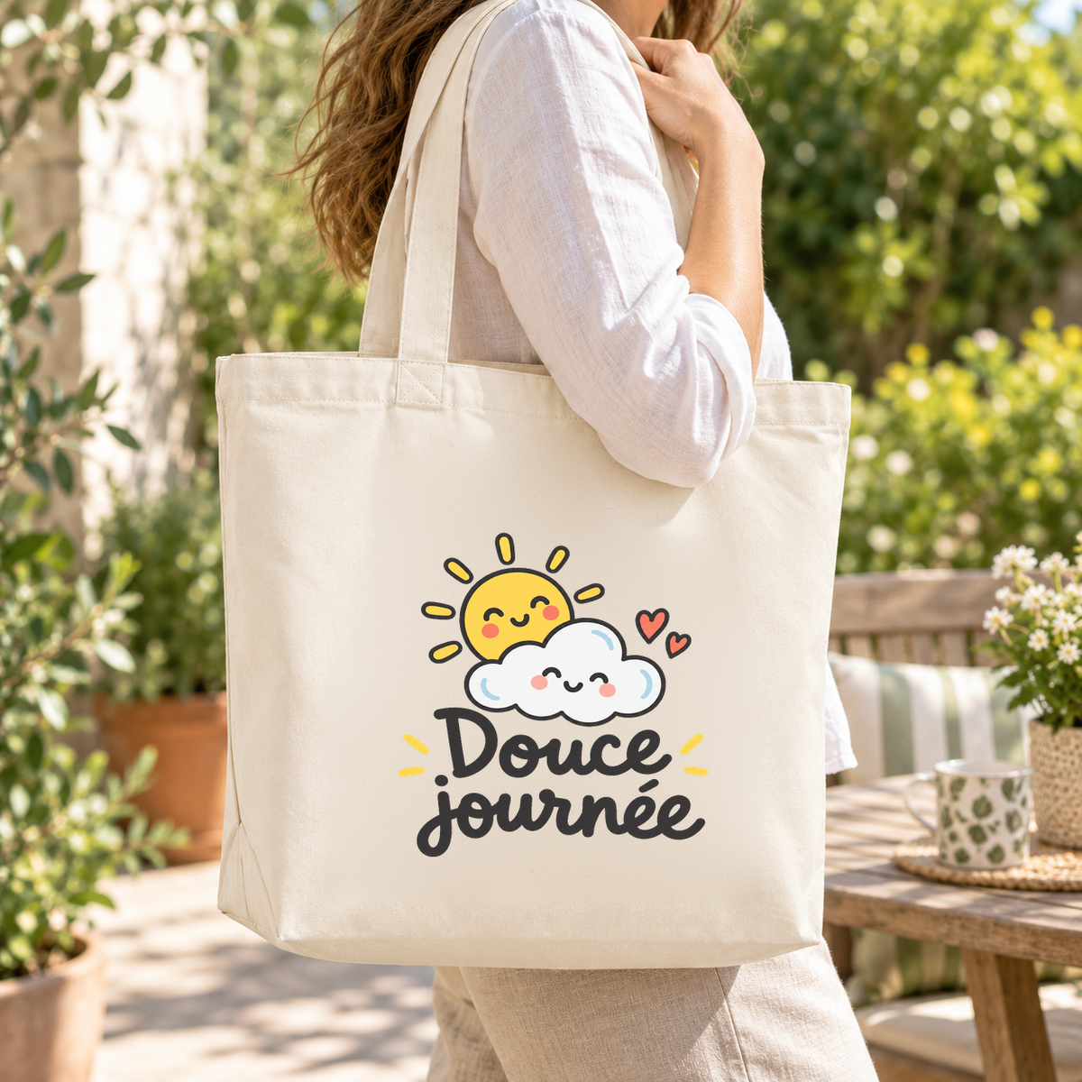 Tote bag « Douce journée » Premium porté à l'épaule dans un jardin ensoleillé