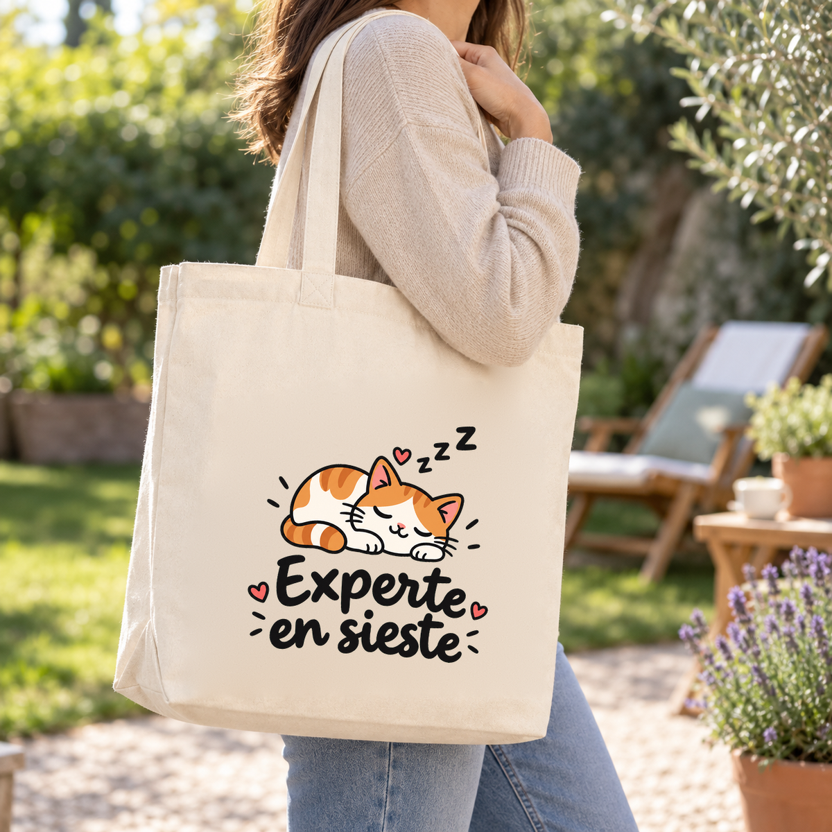 Tote bag « Experte en sieste » Premium porté à l'épaule dans un jardin ensoleillé
