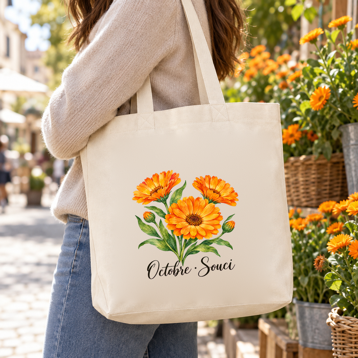 Tote bag fleur de naissance « Octobre · Souci » Premium porté à l'épaule dans une ruelle fleurie de soucis orange