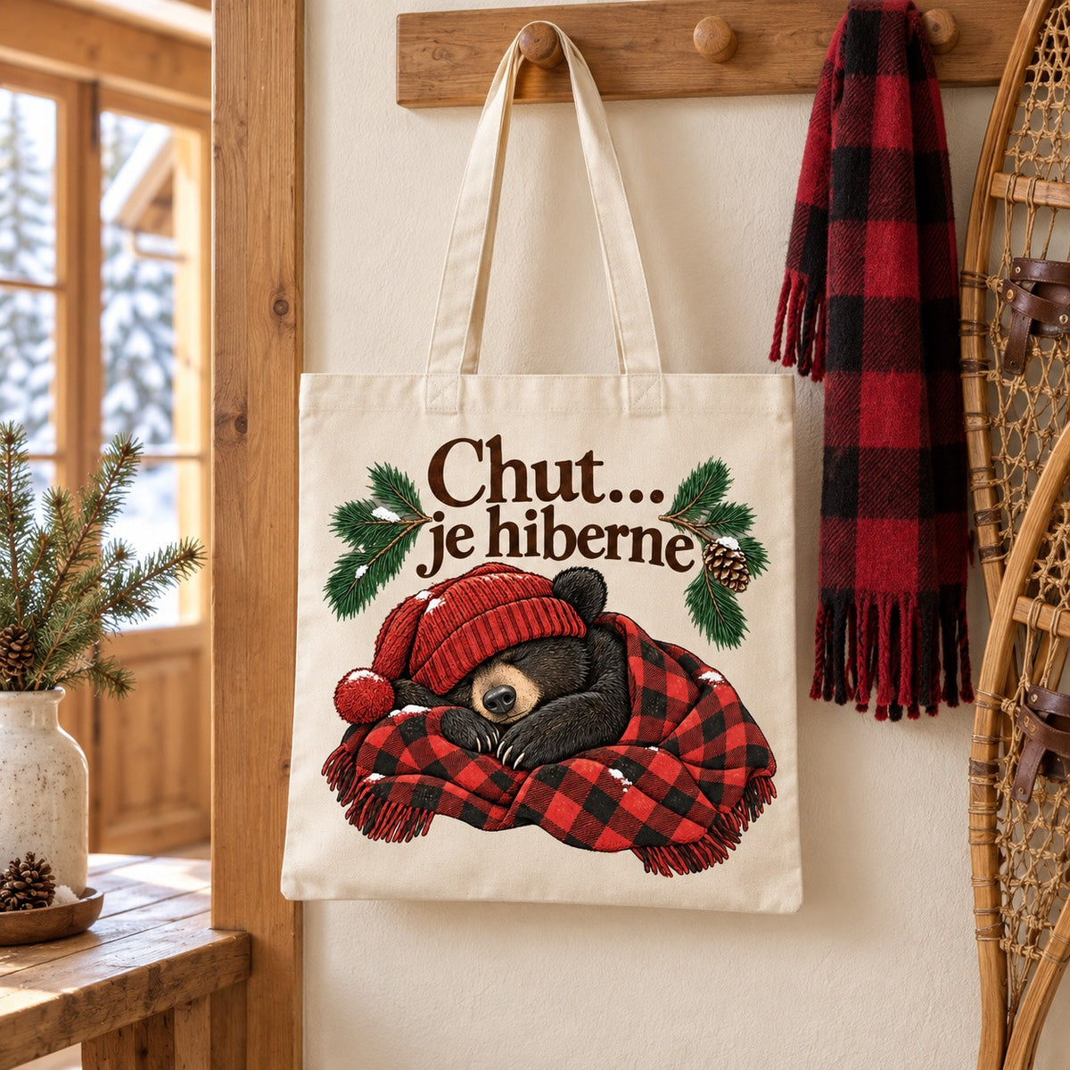 Tote bag « Chut… je hiberne » Essentiel suspendu près d'une paire de raquettes