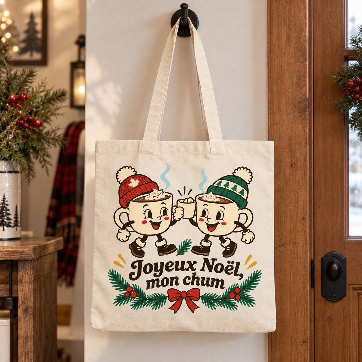 Tote bag « Joyeux Noël, mon chum » Essentiel suspendu à une patère dans une entrée