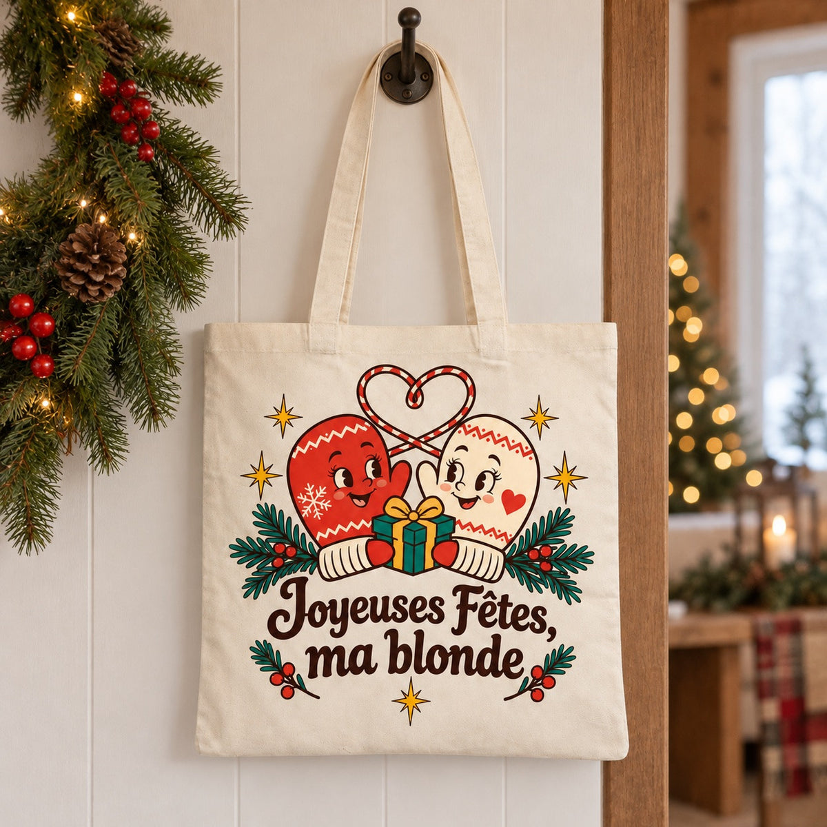 Tote bag « Joyeuses Fêtes, ma blonde » Essentiel suspendu à une patère dans une entrée