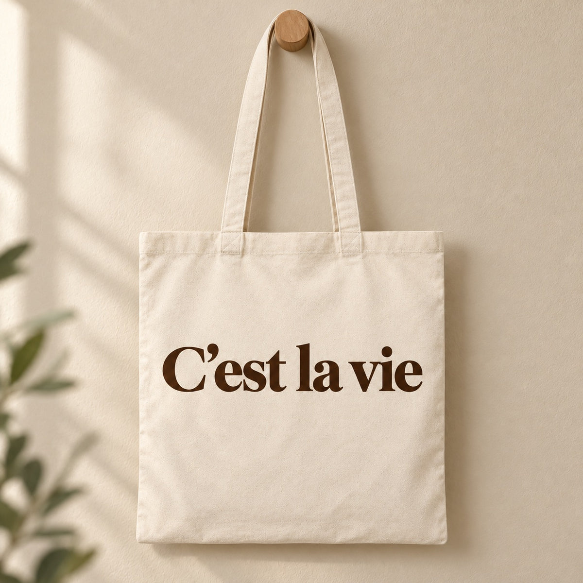 Tote bag « C'est la vie » Essentiel suspendu à une patère