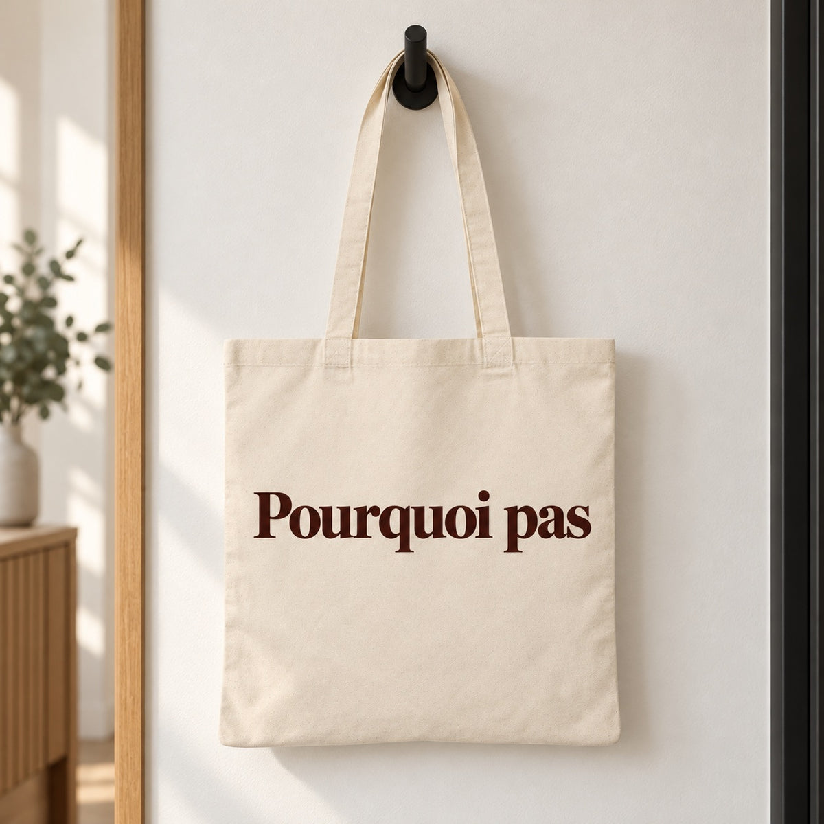 Tote bag « Pourquoi pas » Essentiel suspendu à une patère