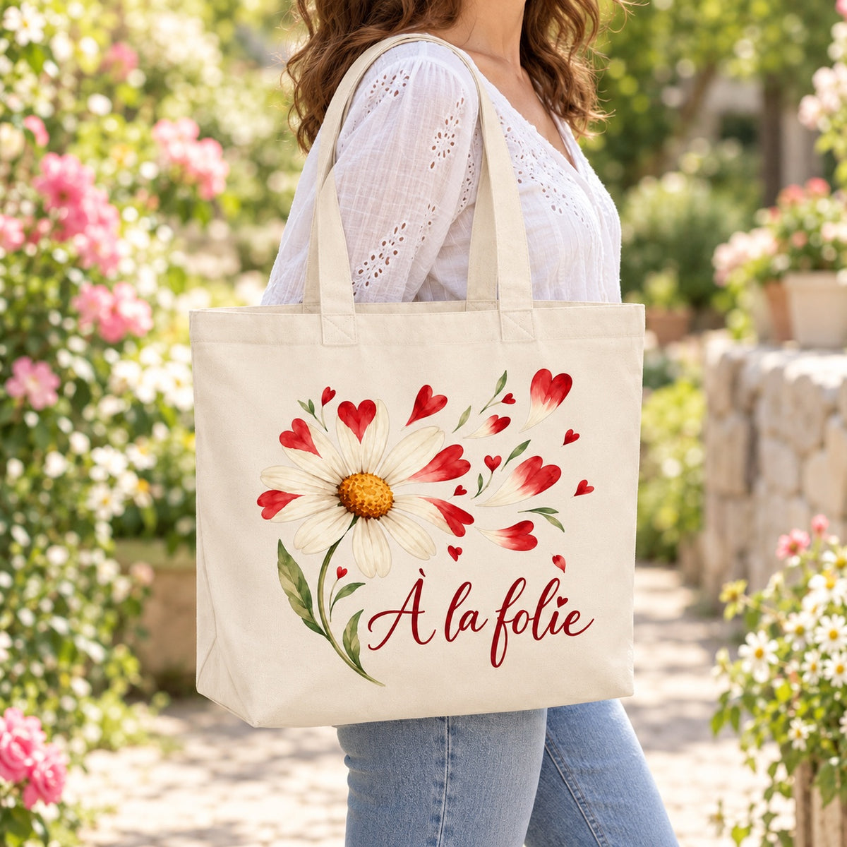 Tote bag « À la folie » Premium porté à l'épaule dans un jardin fleuri