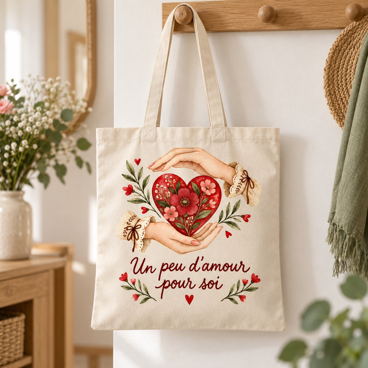 Tote bag « Un peu d’amour pour soi » Essentiel suspendu à une patère dans une entrée lumineuse