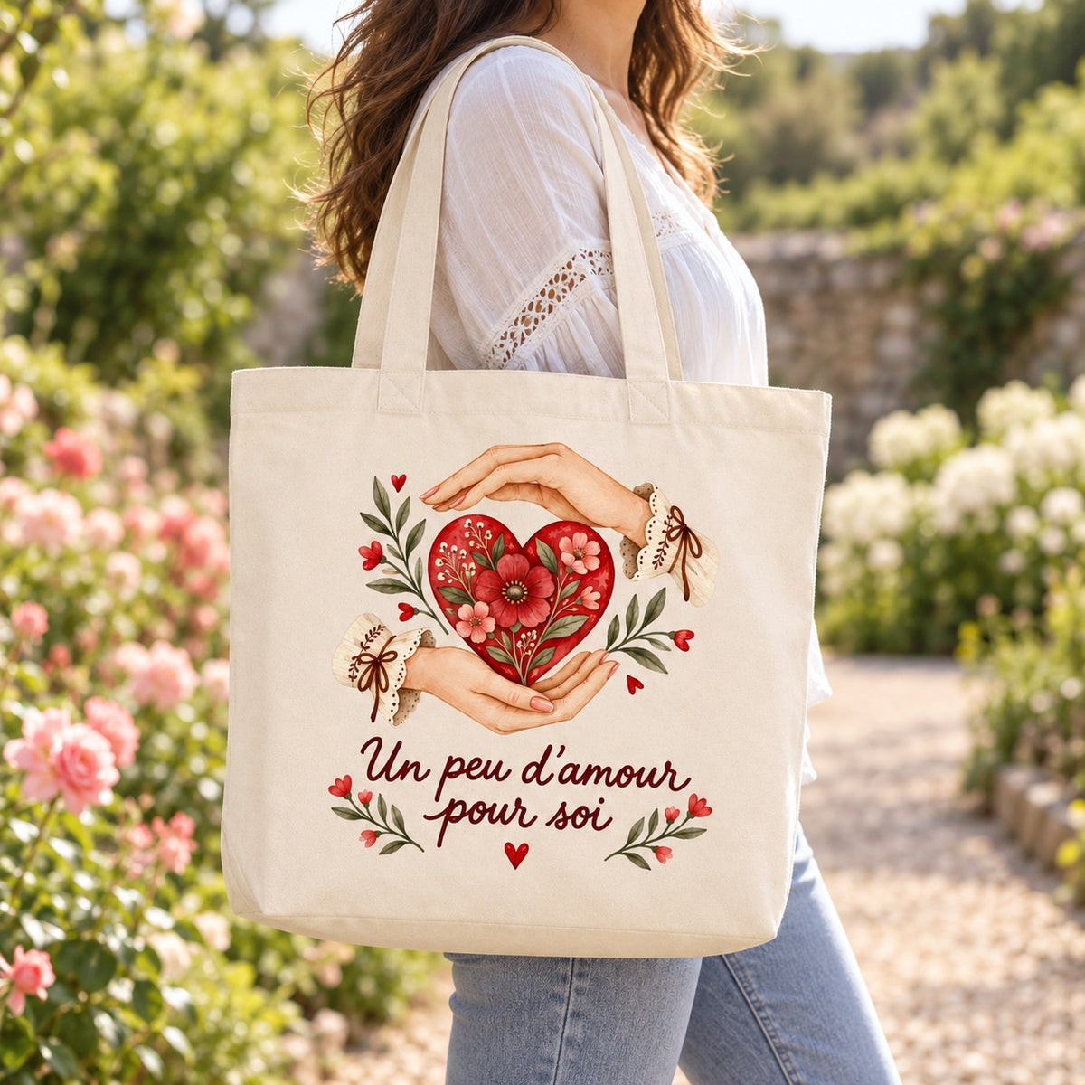 Tote bag « Un peu d’amour pour soi » Premium porté à l'épaule dans un jardin fleuri