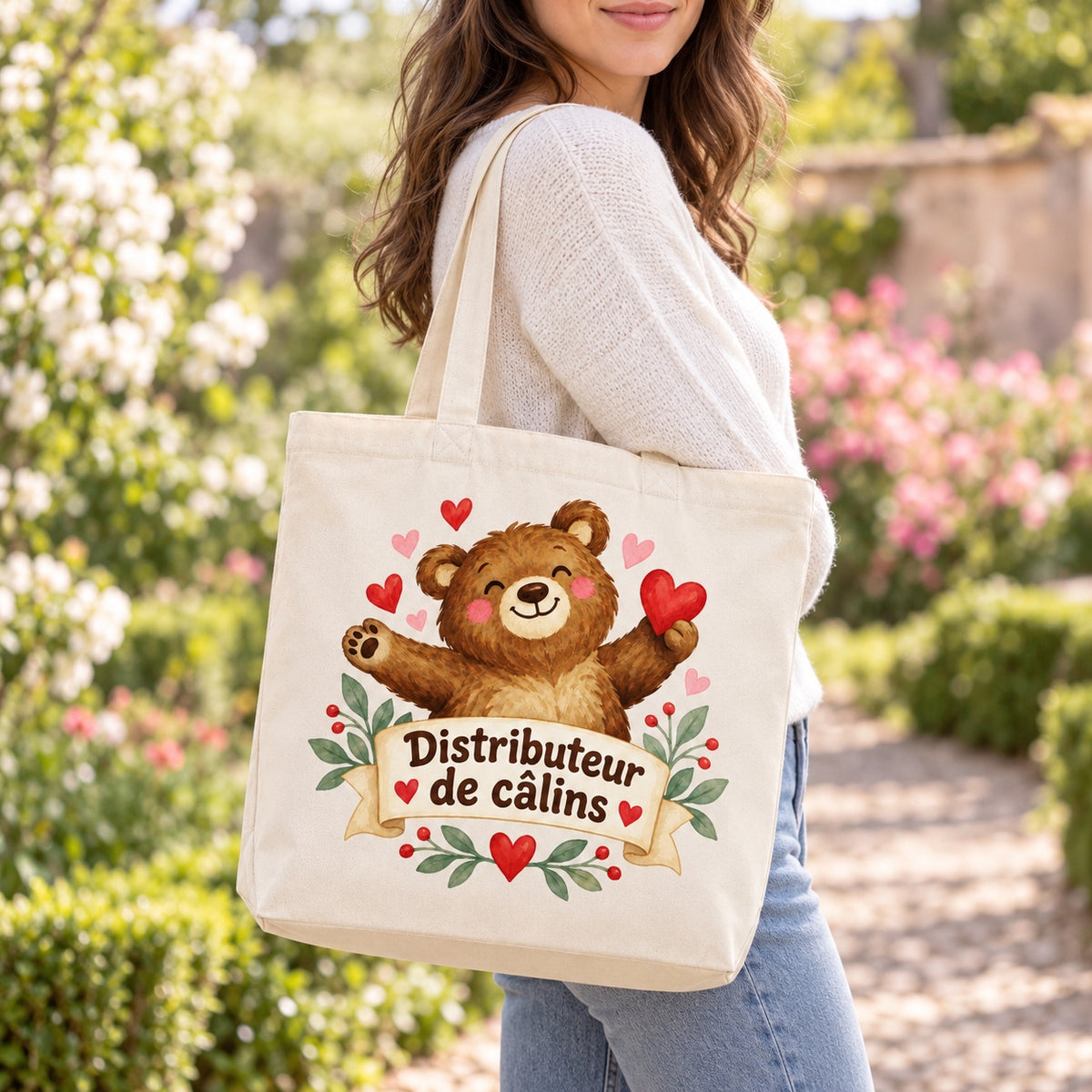 Tote bag « Distributeur de câlins » Premium porté à l'épaule dans un jardin fleuri