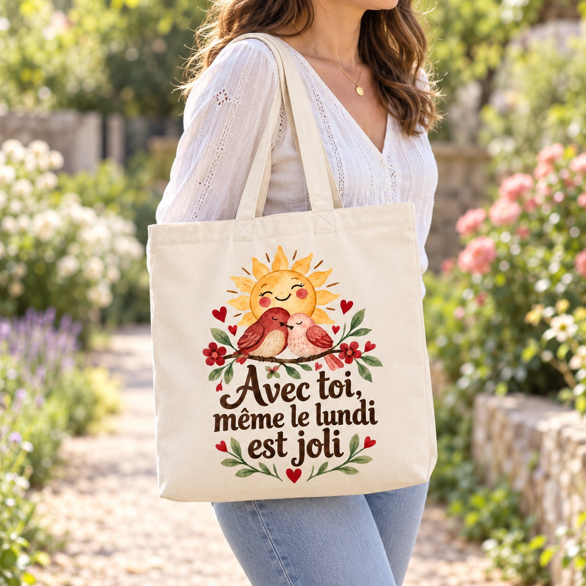 Tote bag « Avec toi, même le lundi est joli » Premium porté à l'épaule dans un jardin fleuri