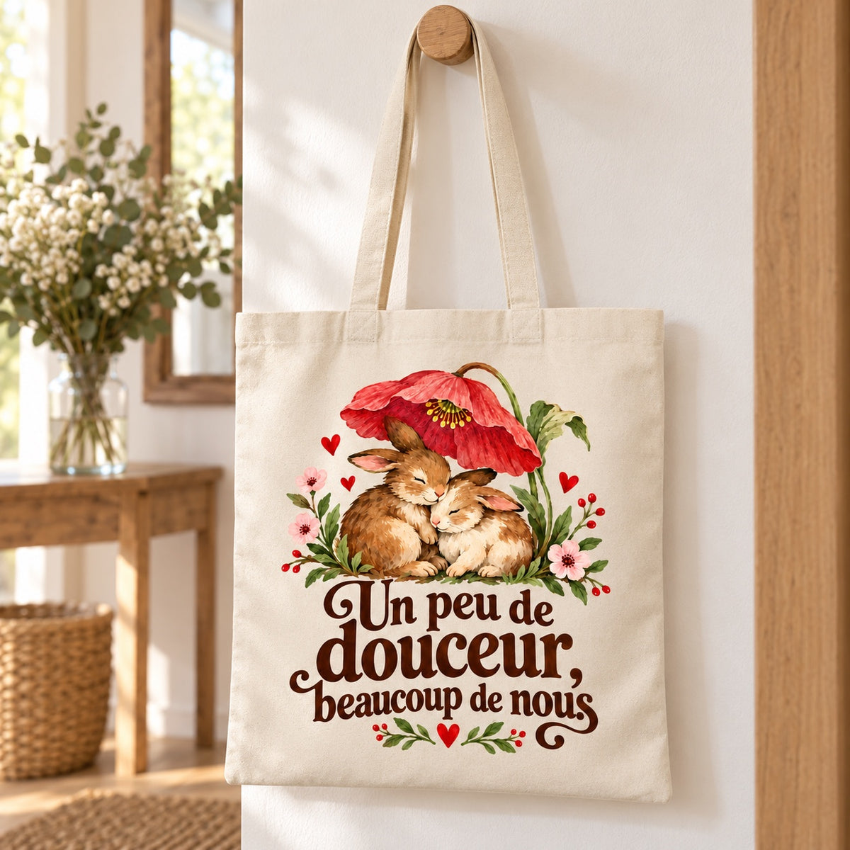 Tote bag « Un peu de douceur, beaucoup de nous » Essentiel suspendu à une patère dans une entrée lumineuse
