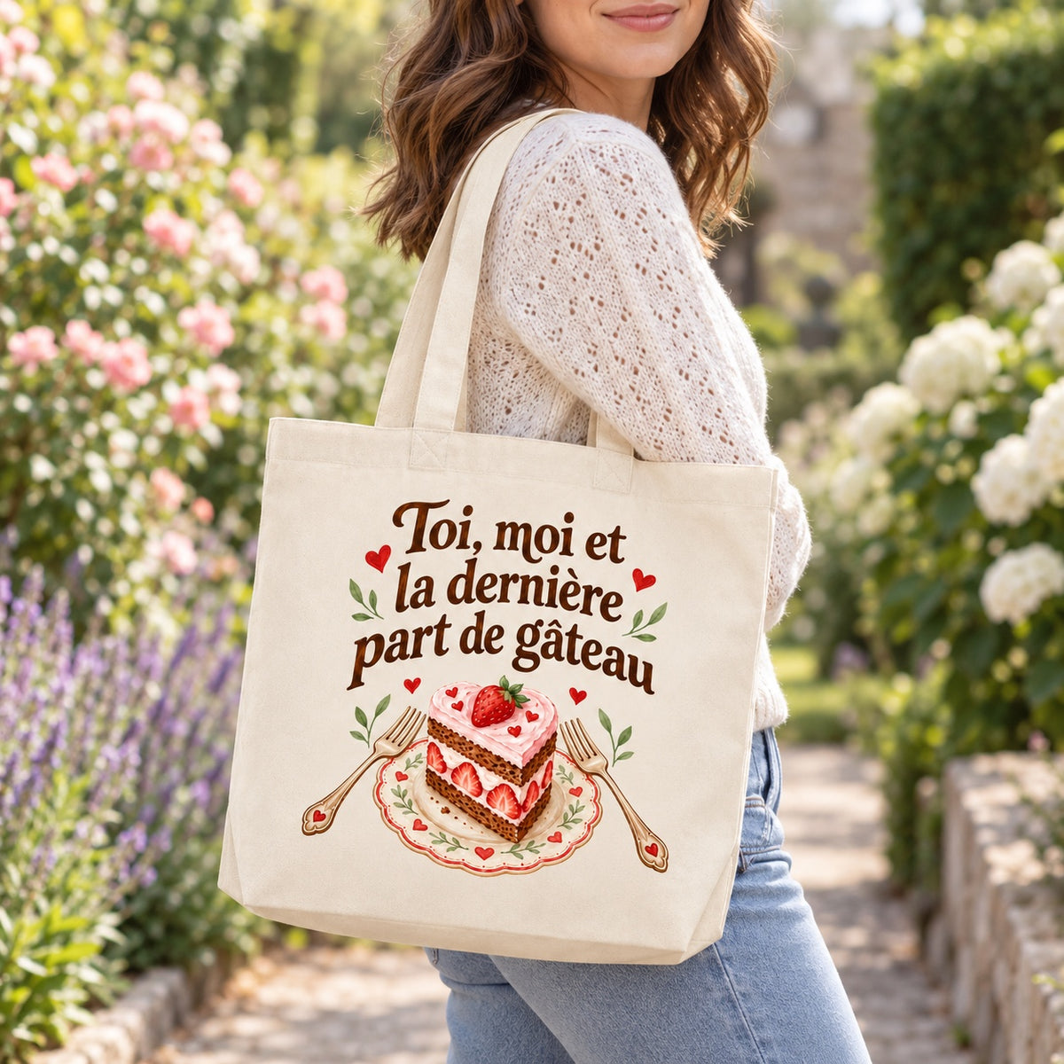 Tote bag « Toi, moi et la dernière part de gâteau » Premium porté à l'épaule dans un jardin fleuri