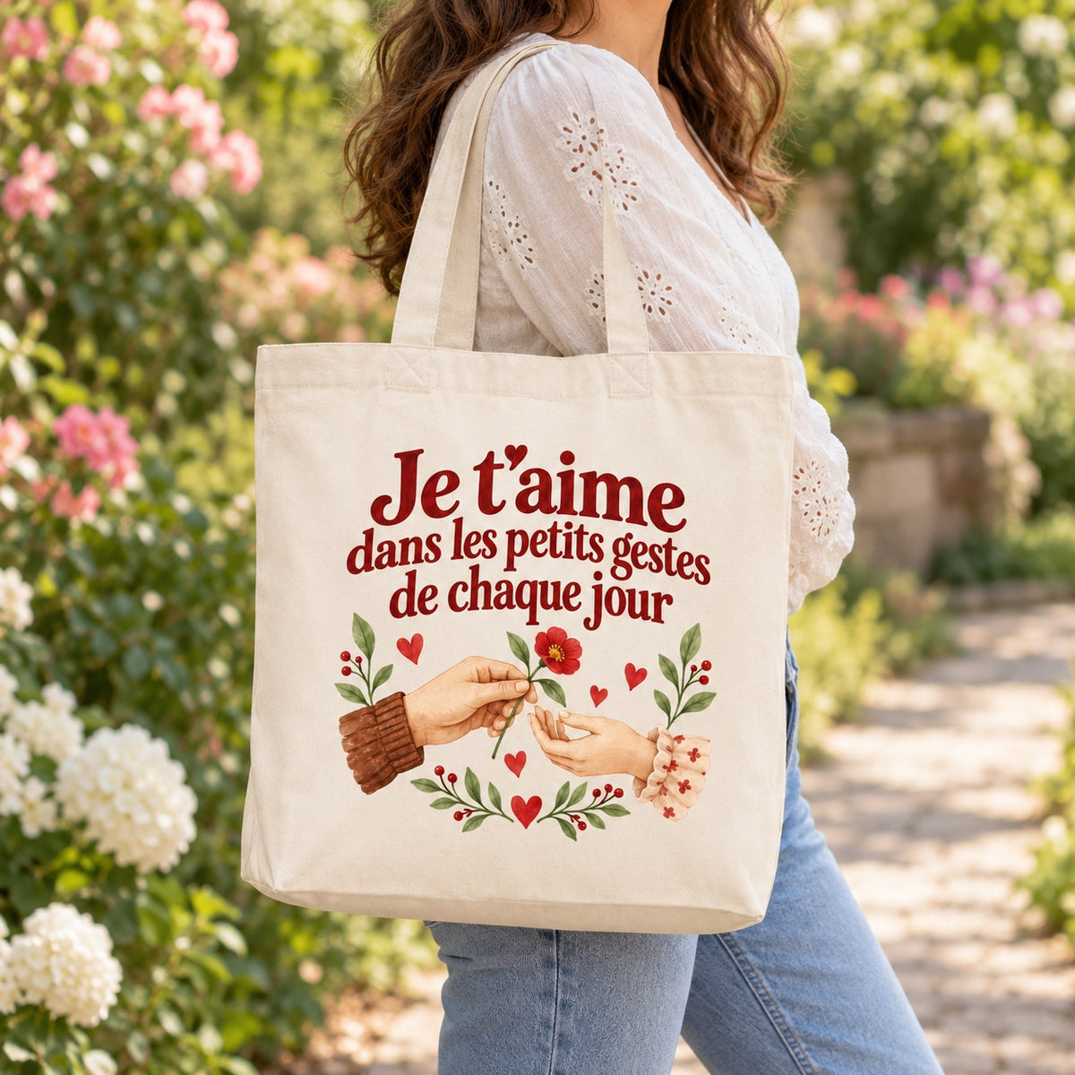 Tote bag « Je t’aime dans les petits gestes de chaque jour » Premium porté à l'épaule dans un jardin fleuri
