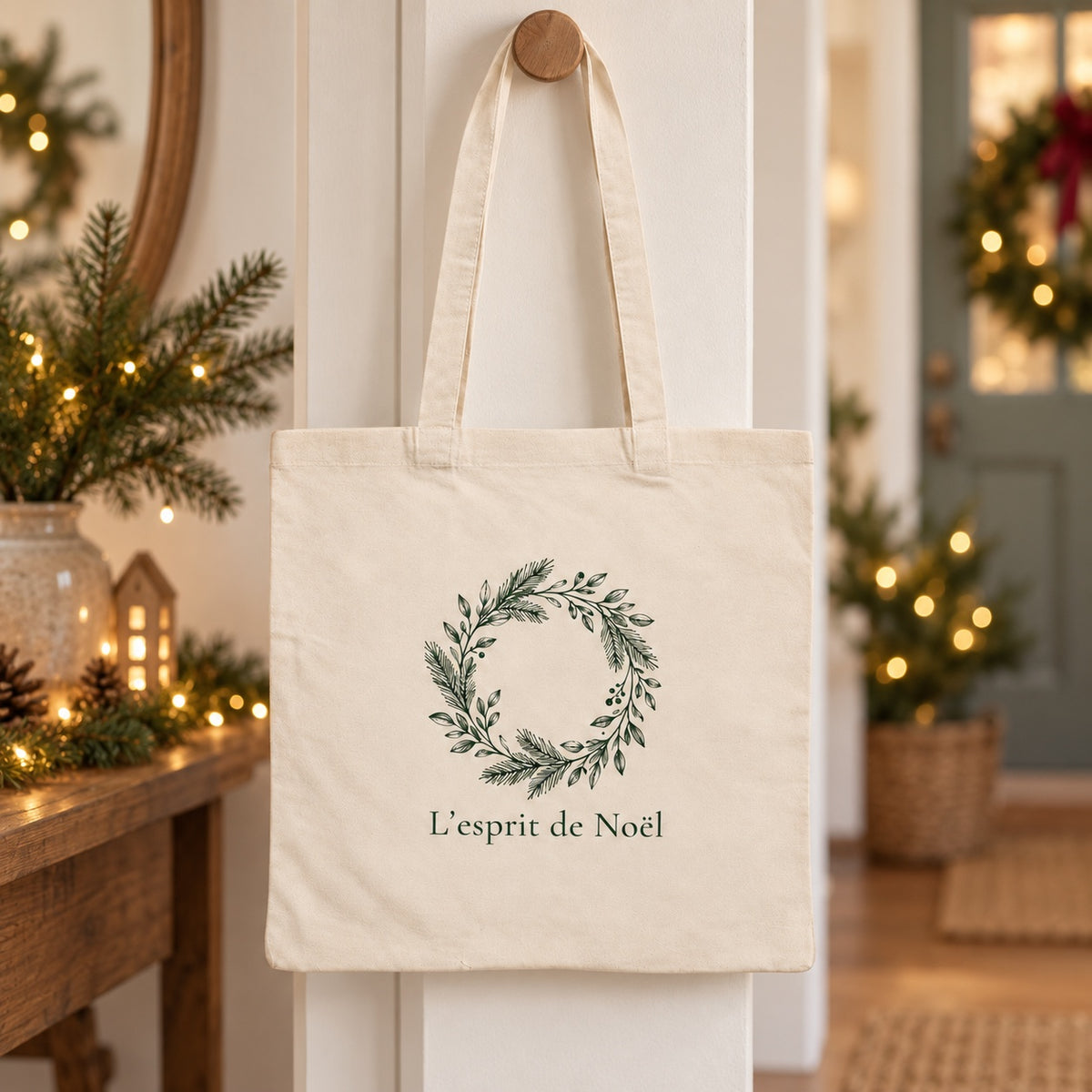 Tote bag de Noël « L’esprit de Noël » Essentiel suspendu à une patère dans une entrée décorée pour Noël