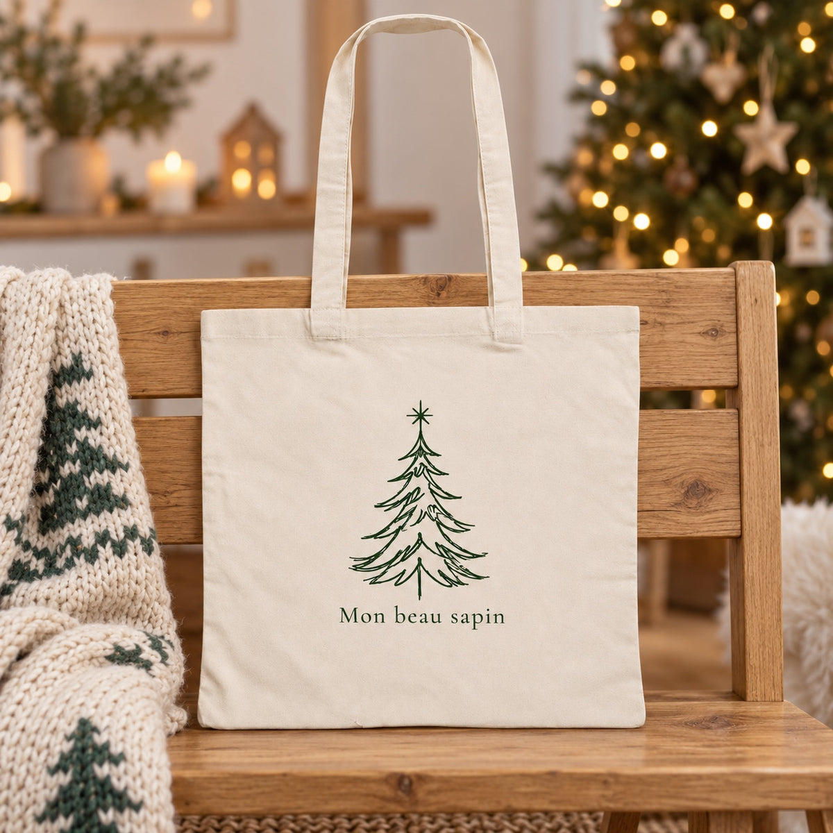 Tote bag de Noël « Mon beau sapin » Essentiel appuyé contre un banc près d'un plaid de Noël