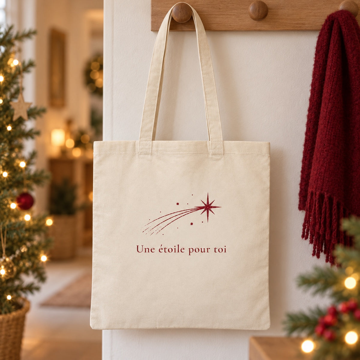 Tote bag de Noël « Une étoile pour toi » Essentiel suspendu à une patère dans une entrée décorée pour Noël