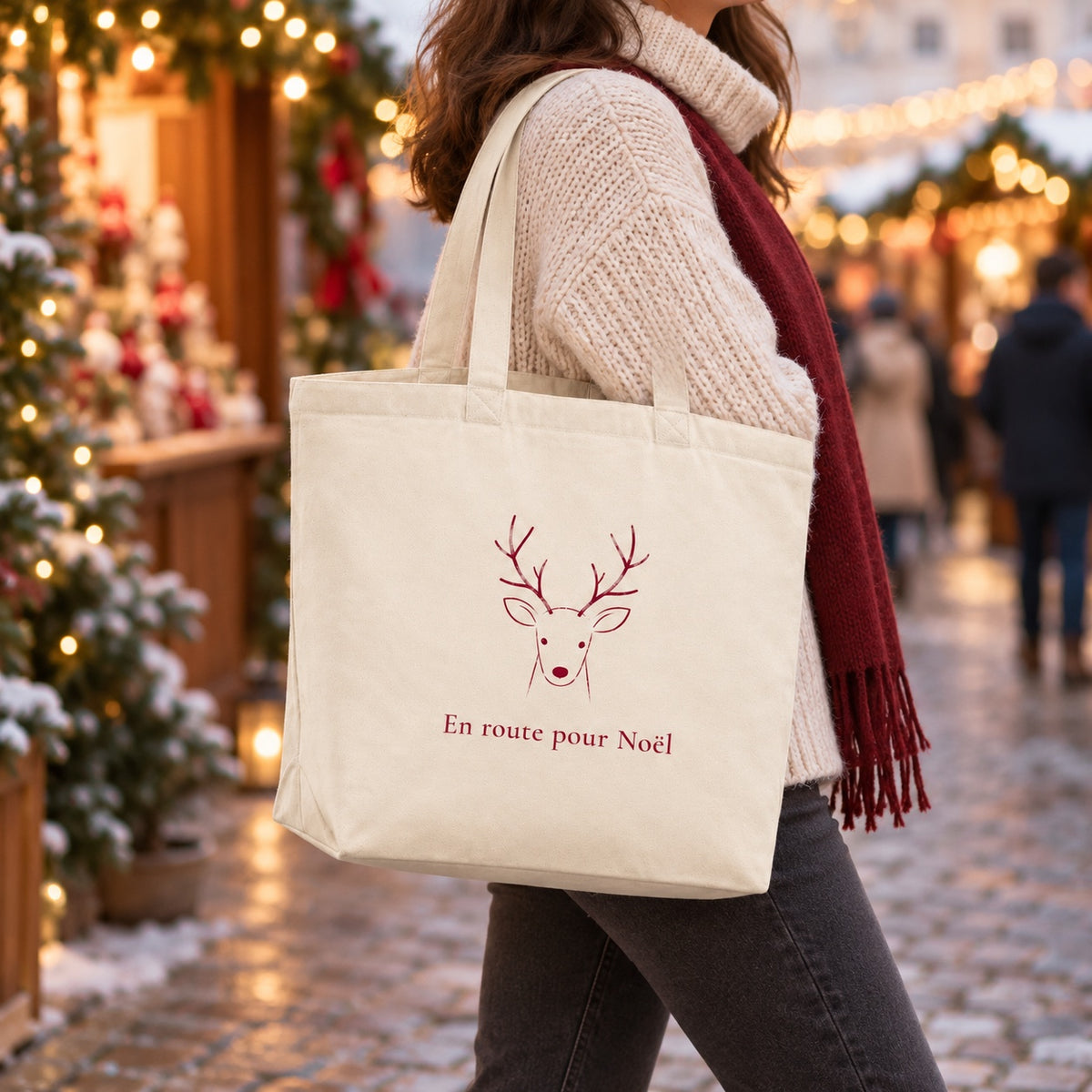 Tote bag de Noël « En route pour Noël » Premium porté à l'épaule dans un marché de Noël