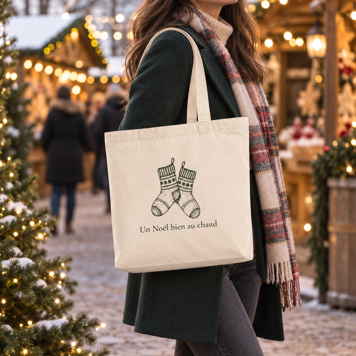 Tote bag de Noël « Un Noël bien au chaud » Premium porté à l'épaule dans un marché de Noël
