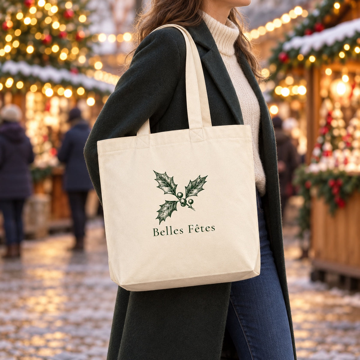 Tote bag de Noël « Belles Fêtes » Premium porté à l'épaule dans un marché de Noël