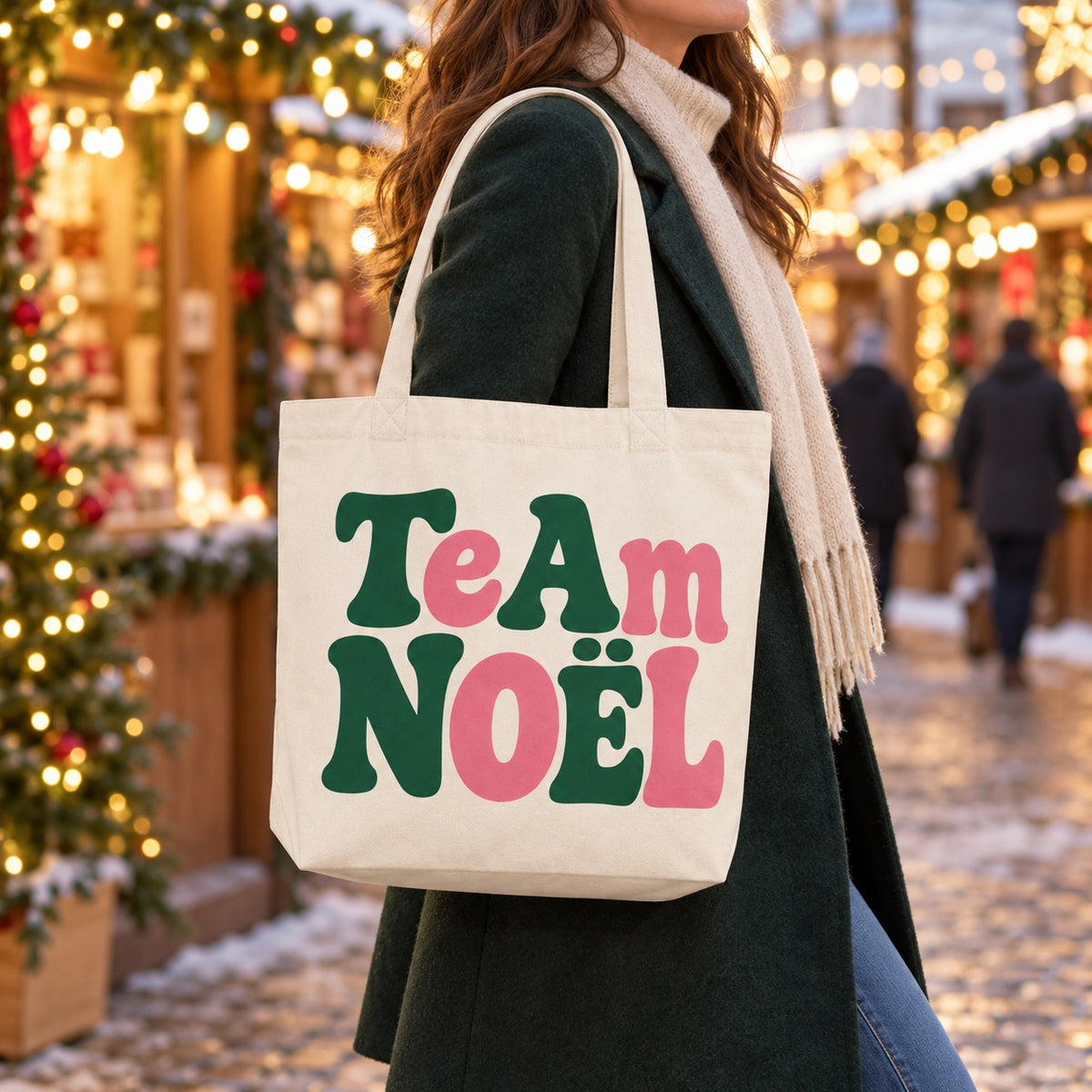 Tote bag de Noël « Team Noël » Premium porté à l'épaule dans un marché de Noël