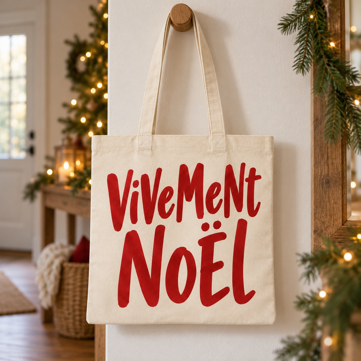 Tote bag de Noël « Vivement Noël » Essentiel suspendu à une patère dans une entrée décorée pour Noël