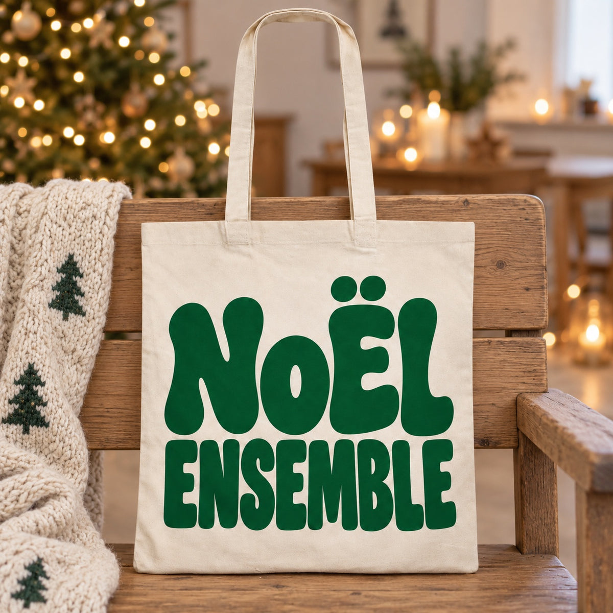 Tote bag de Noël « Noël ensemble » Essentiel appuyé contre un banc près d'un plaid de Noël