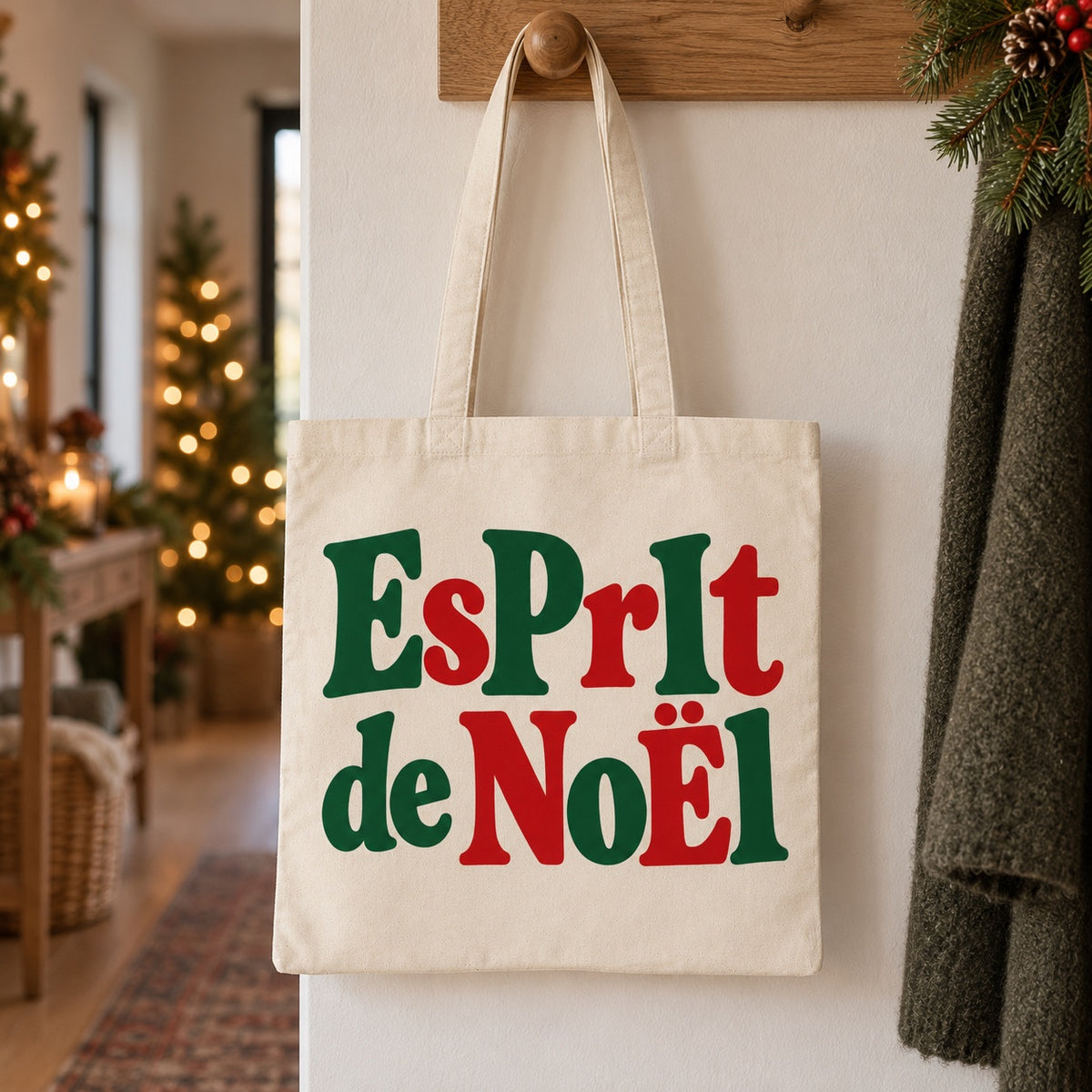 Tote bag de Noël « Esprit de Noël » Essentiel suspendu à une patère dans une entrée décorée pour Noël
