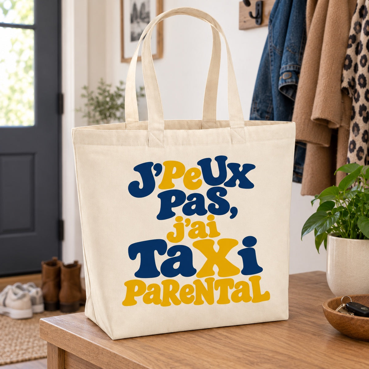 Tote bag « J'peux pas, j'ai taxi parental » Premium posé sur une console d'entrée