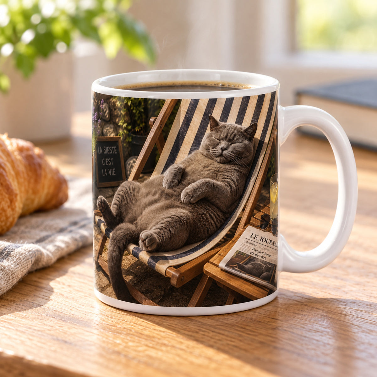 Mug Chat Sieste « La Sieste c'est la Vie » posé sur une table en bois avec un croissant, pause café