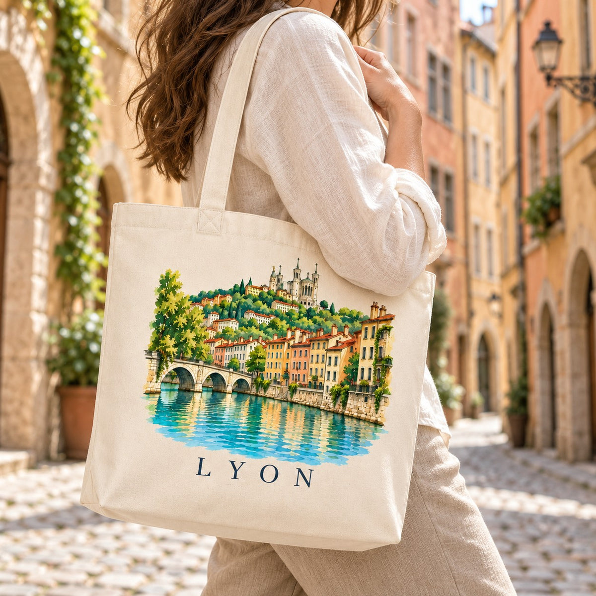 Tote bag Lyon Premium porté à l'épaule dans une ruelle pavée du Vieux-Lyon