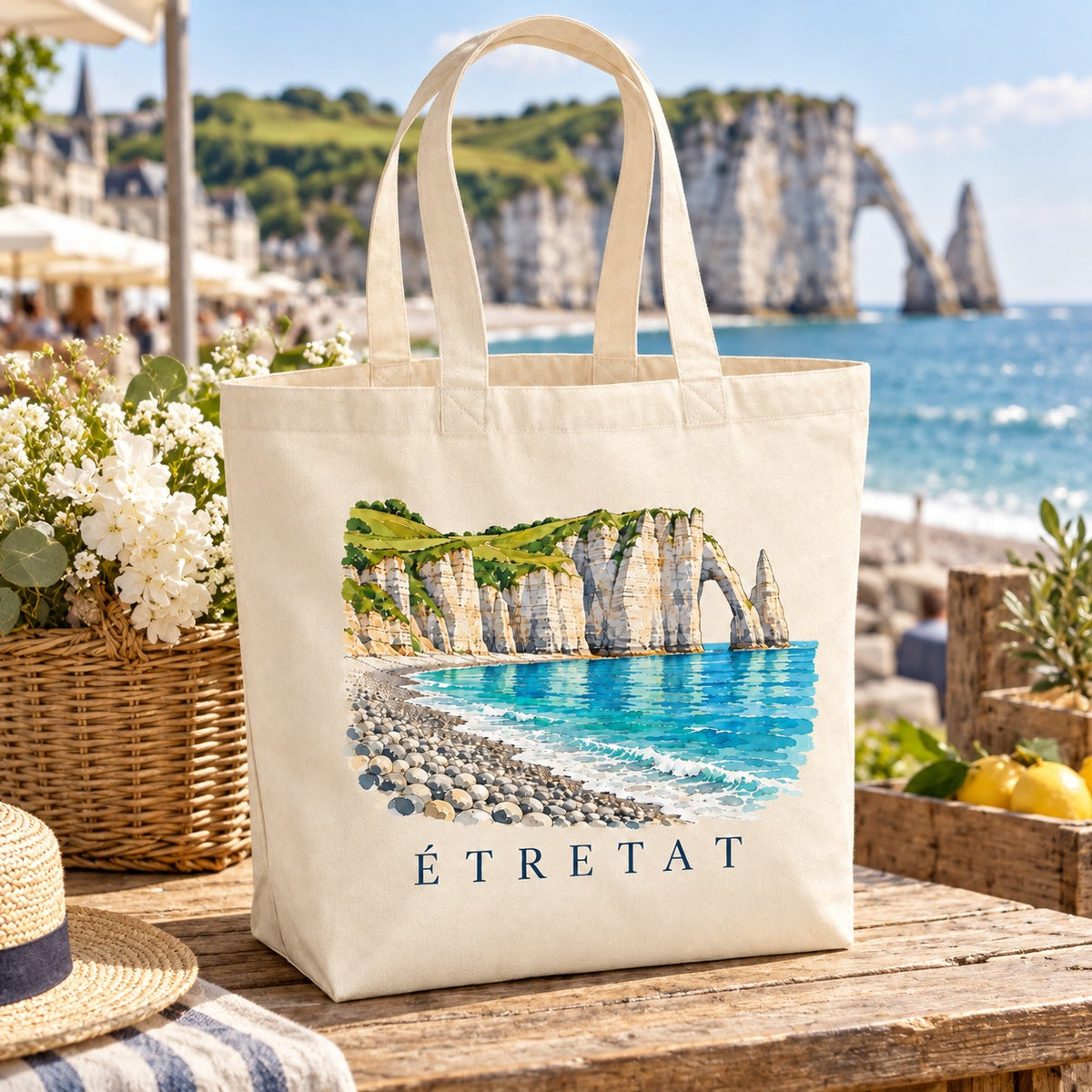 Tote bag Étretat Premium posé sur un étal face à la mer, avec des fleurs