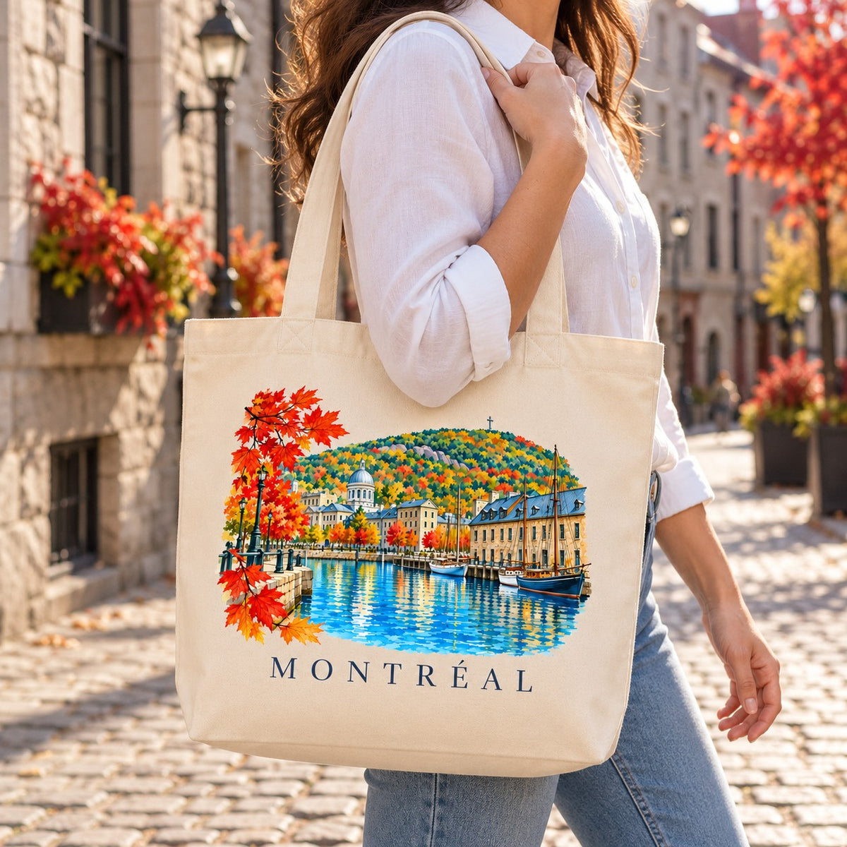 Tote bag Montréal Premium porté à l'épaule dans une rue pavée du Vieux-Montréal aux couleurs de l'automne