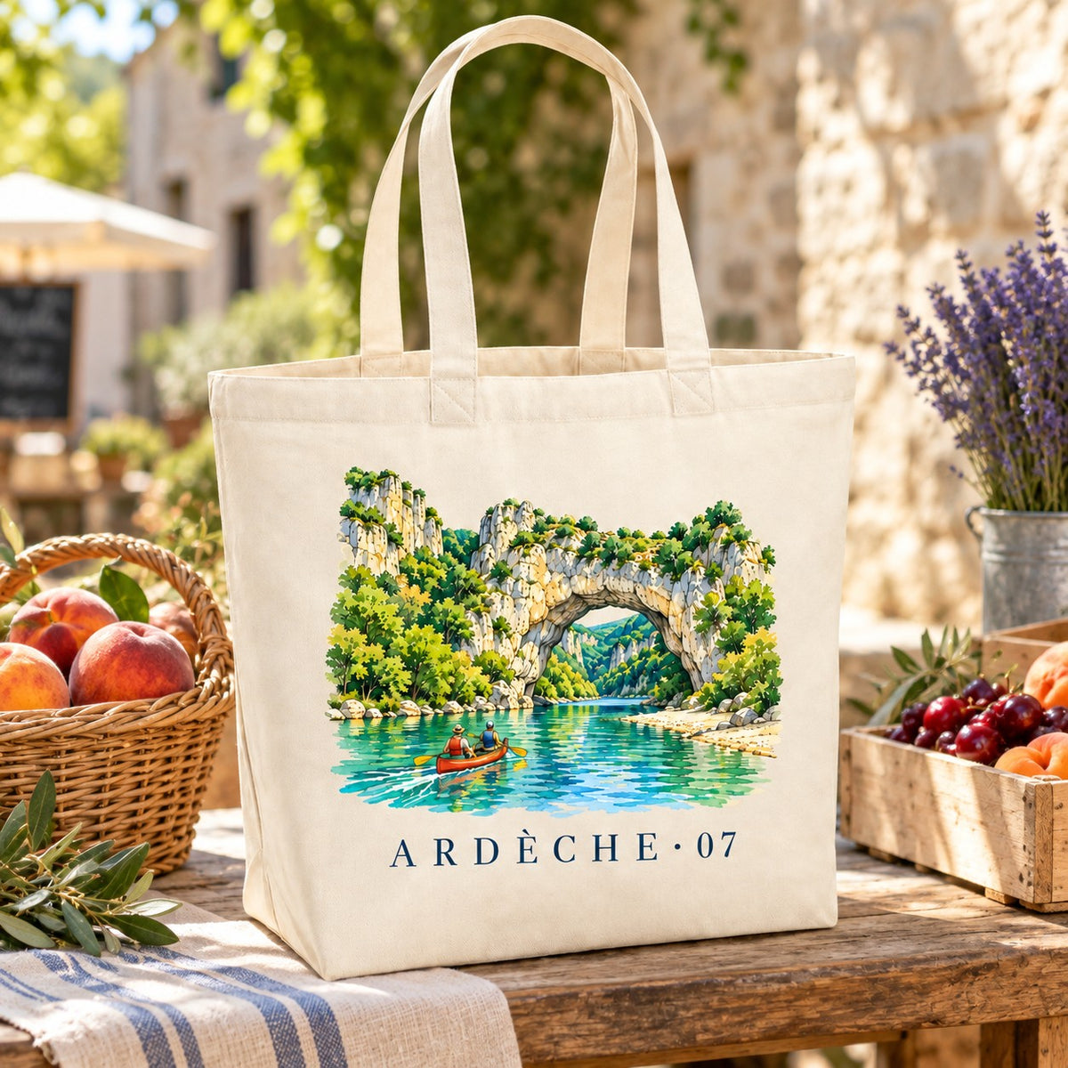 Tote bag Ardèche (07) Premium posé sur un étal de marché avec des pêches et des cerises
